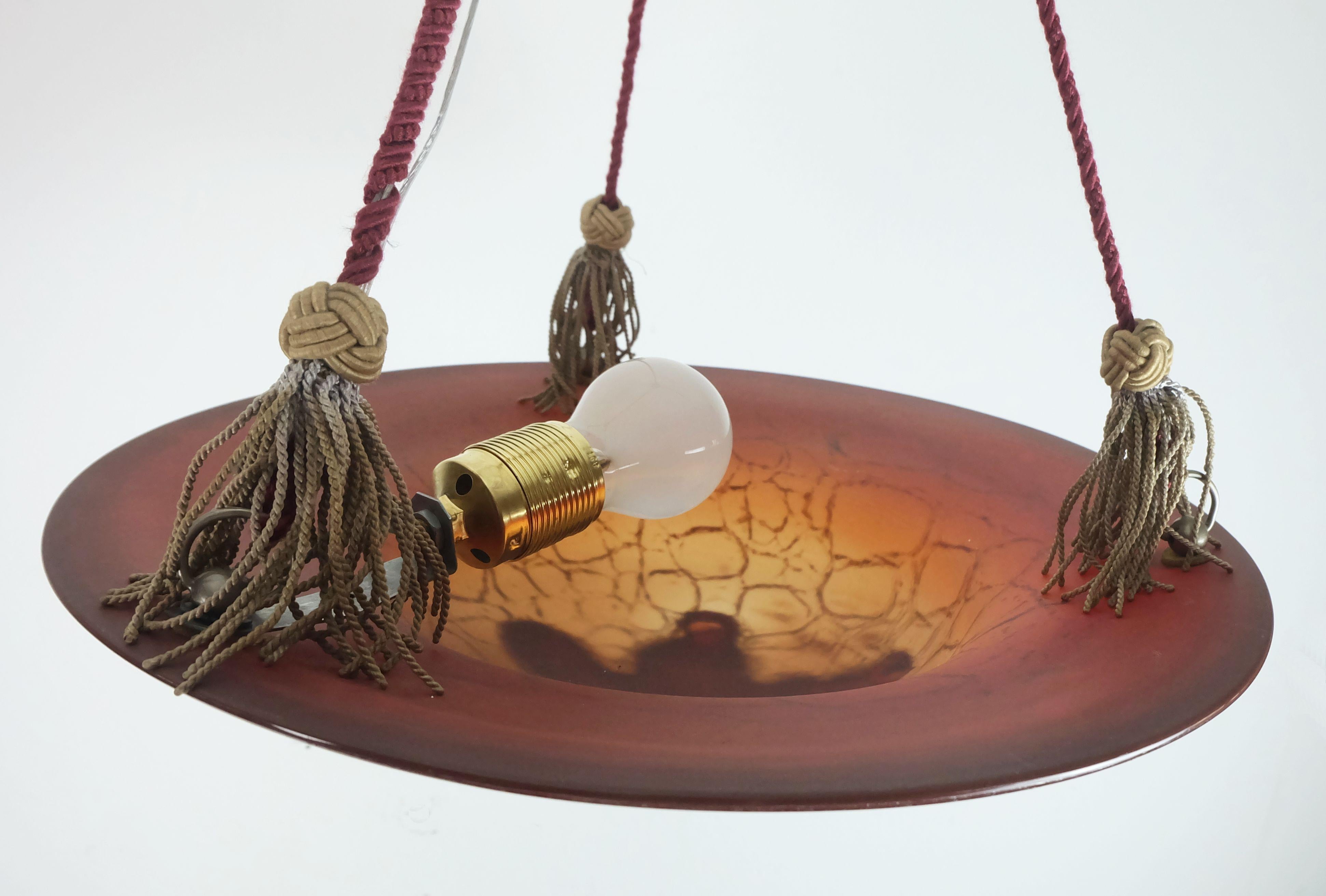 Bellissima lampada a sospensione degli anni '1930. Grande paralume a forma di ciotola in vetro Ikora di WMF Ikora con la tipica marmorizzazione espressiva e i colori intensi. Il paralume è appeso a tre corde rosse e il filo viene fatto passare