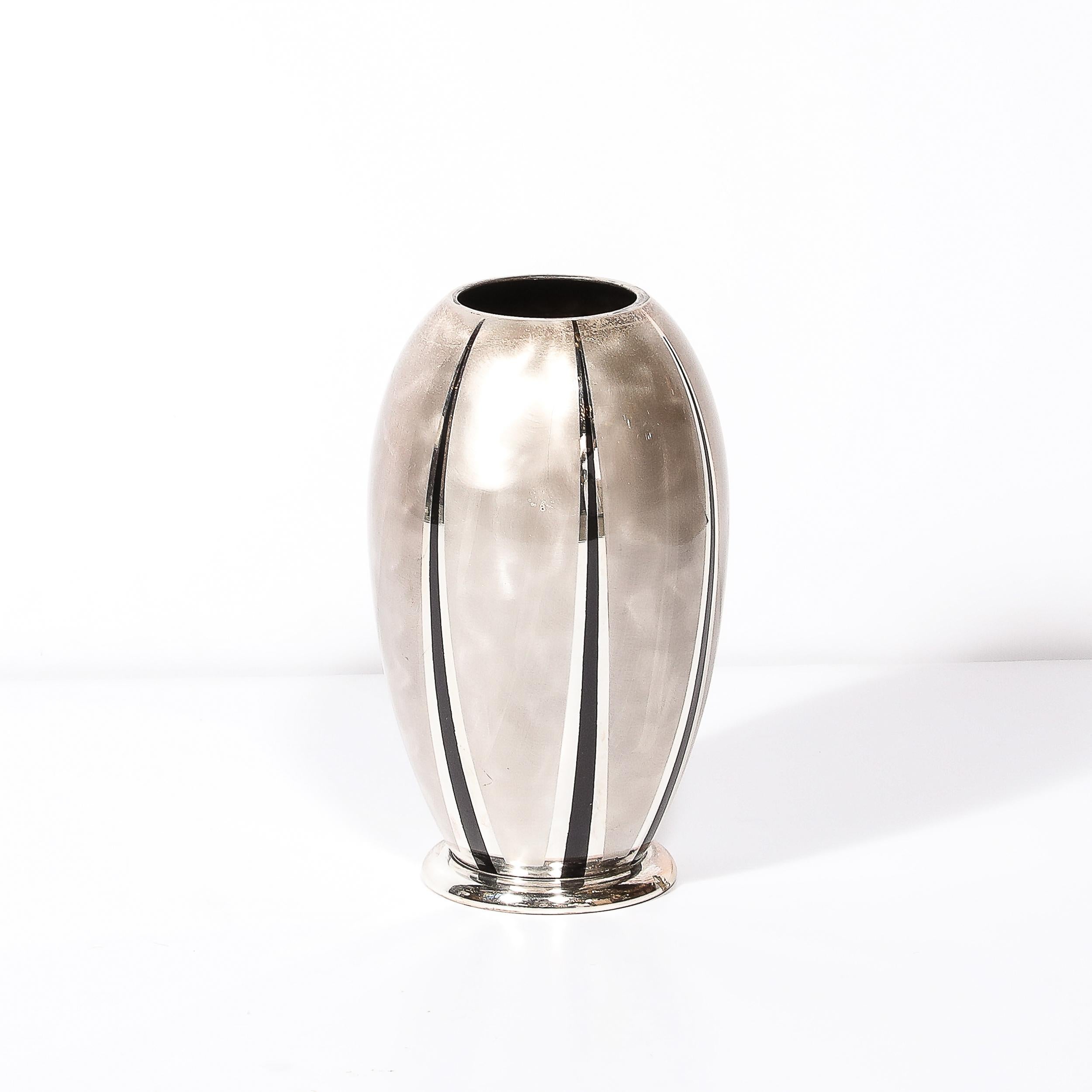 Este jarrón chapado en plata con textura MF Ikora de estilo Art decó, bien equilibrado y con un acabado impresionante, con detalles lineales en negro azabache, procede de Alemania, circa 1935. Con una composición redondeada en forma de urna que