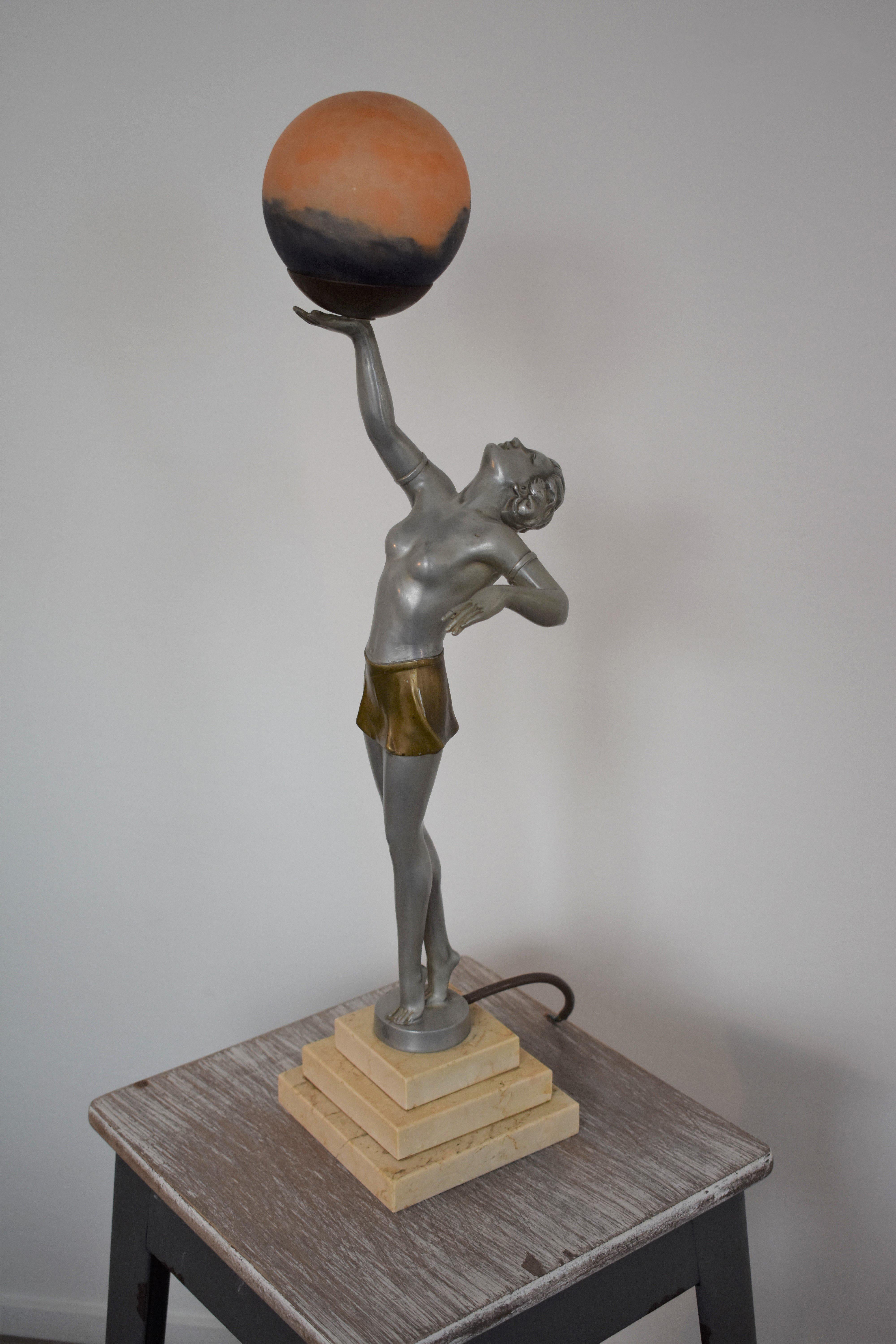 Information:
This original art deco piece features a nude woman holding a glass globe over her head. The globe lights up when turned on. The lamp is in the style of the famous Max le Verrier lamps. However it is most likely made by Enrique Molins
