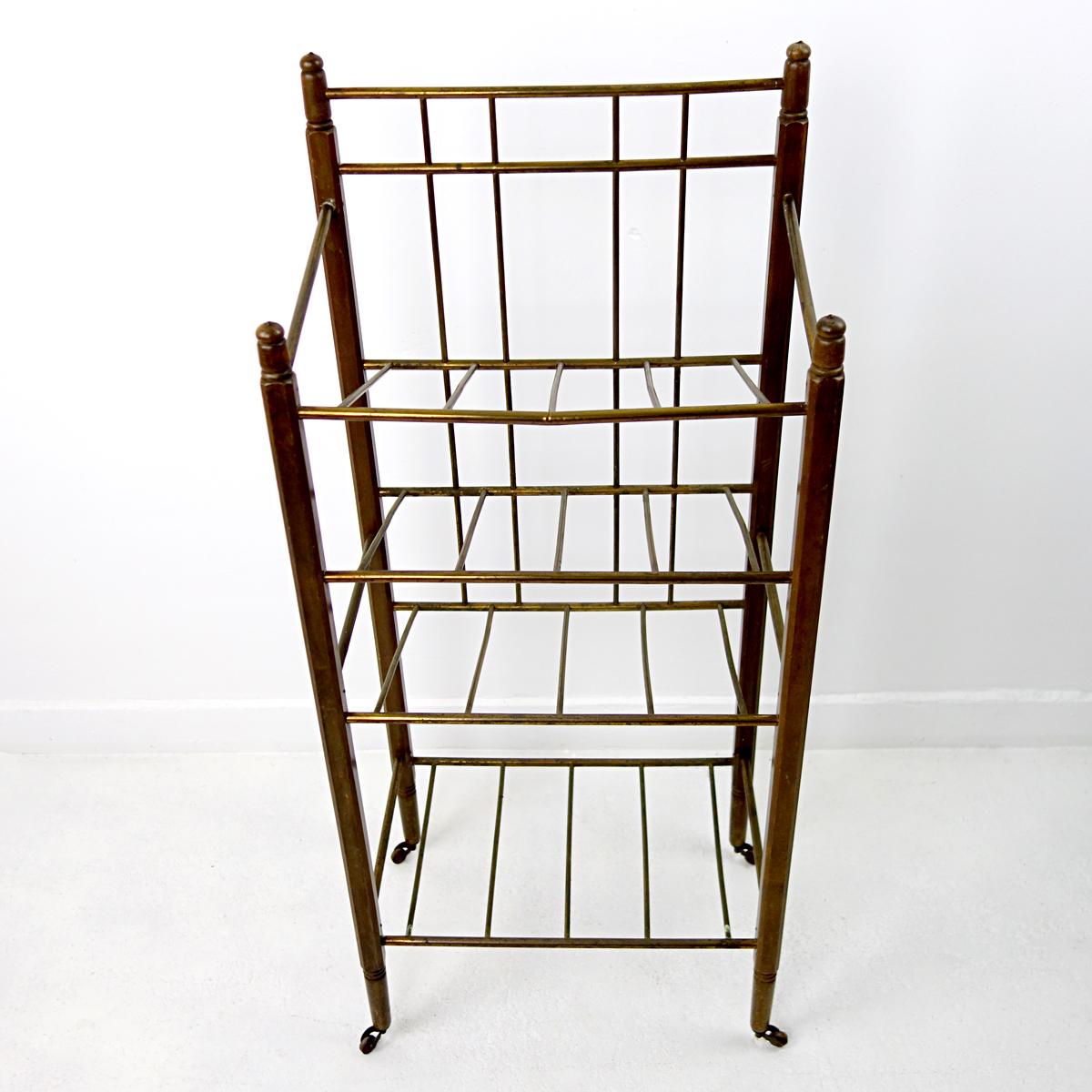 This Art Deco magazine stand was produced by Ernst Rockhausen & Söhne. 
Its frame is made of ebonized mahogany and it has brass tubes to carry your magazines. It sits on four wheels.
This elegant piece would be both a practical as a decorative