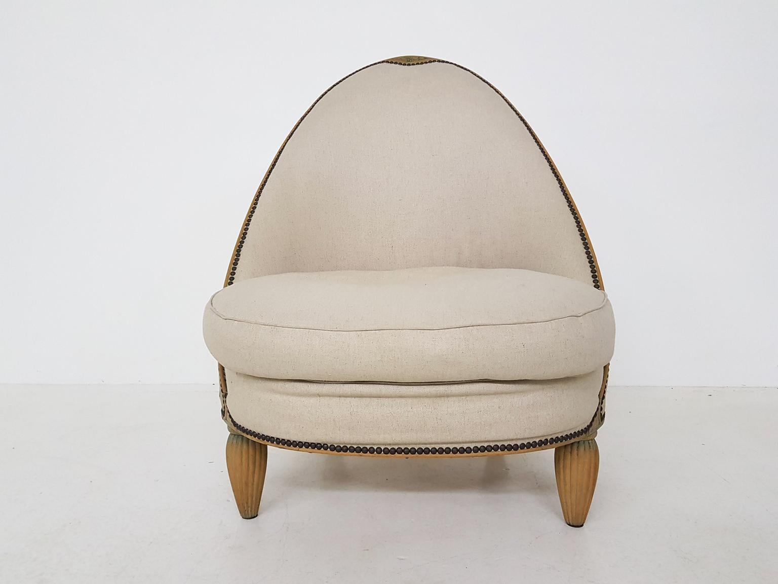 A nice slipper, salon or lounge chair in the style of Art Deco. The chair is in original condition. It has a wooden frame with nice ribbed wooden legs. Its high sharp rounded back still looks very sleek and modern. The fabric is original with traces