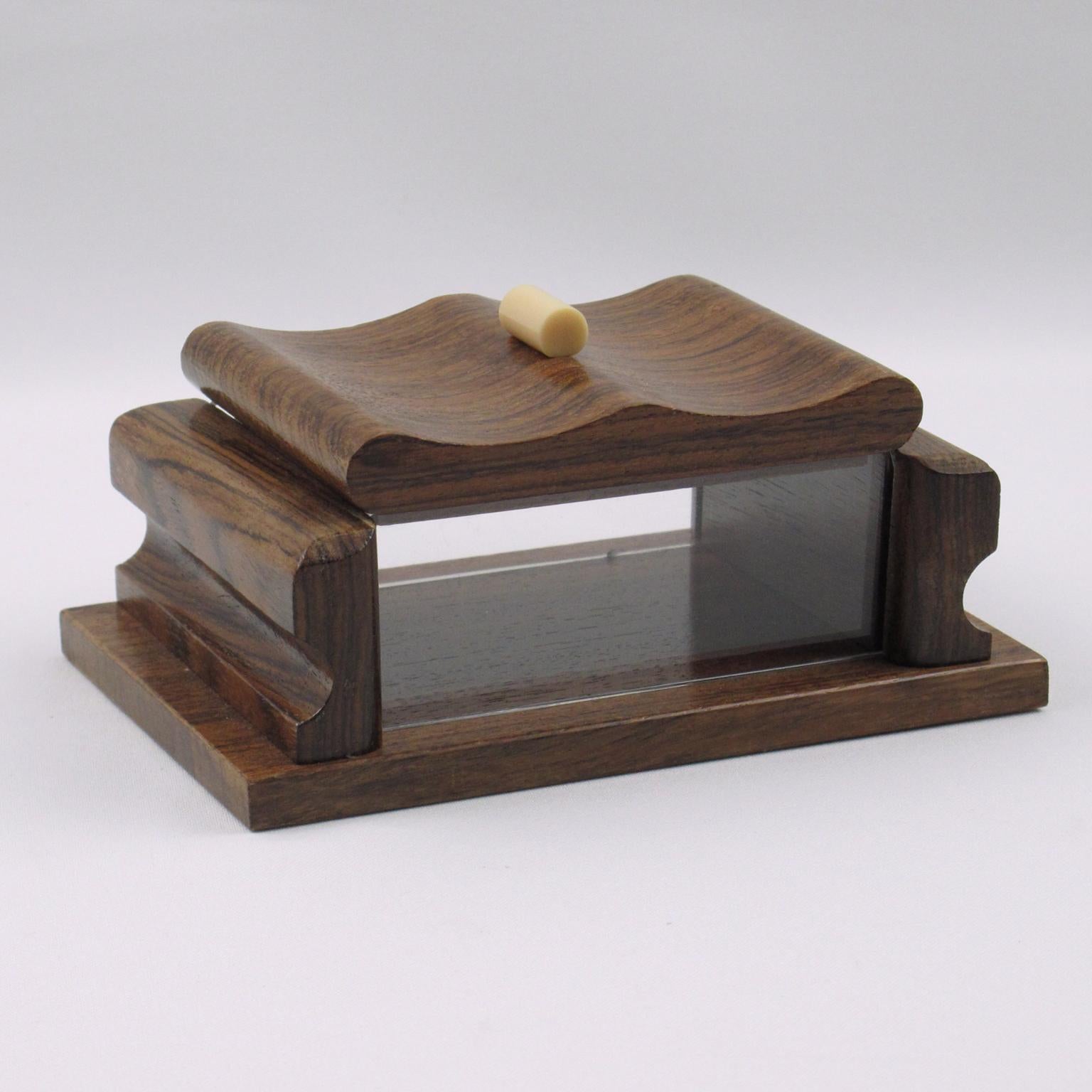 This stunning hand-carved modernist Art Deco decorative lidded box was crafted in France circa 1940. The rectangular shape features solid wood and crystal-clear Lucite on the sides, and is adorned with an ornate off-white Galalith stick handle. The