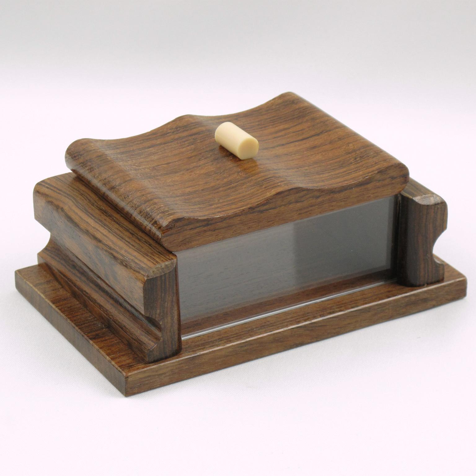 This elegant hand-carved modernist Art Deco decorative lidded box was crafted in France circa 1940. The rectangular shape has solid wood and crystal clear Lucite on the sides and is ornate with an off-white Galalith stick handle. The original