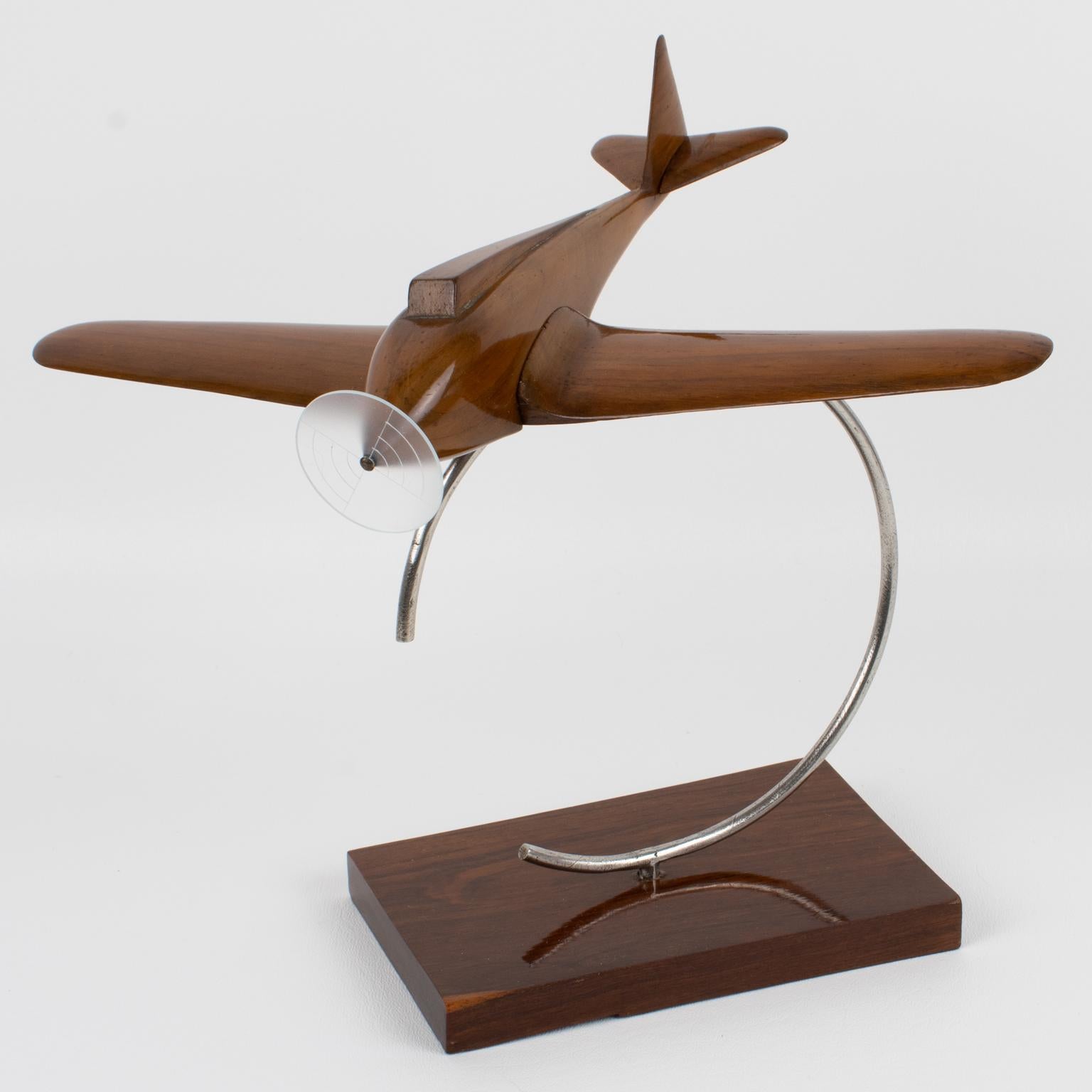 Stunning Art Deco wood airplane propeller model mounted on a geometric wood and metal display. This Art Deco model airplane is crafted from solid wood and features a lovely, warm patina. It features one large Lucite propeller (note that the original