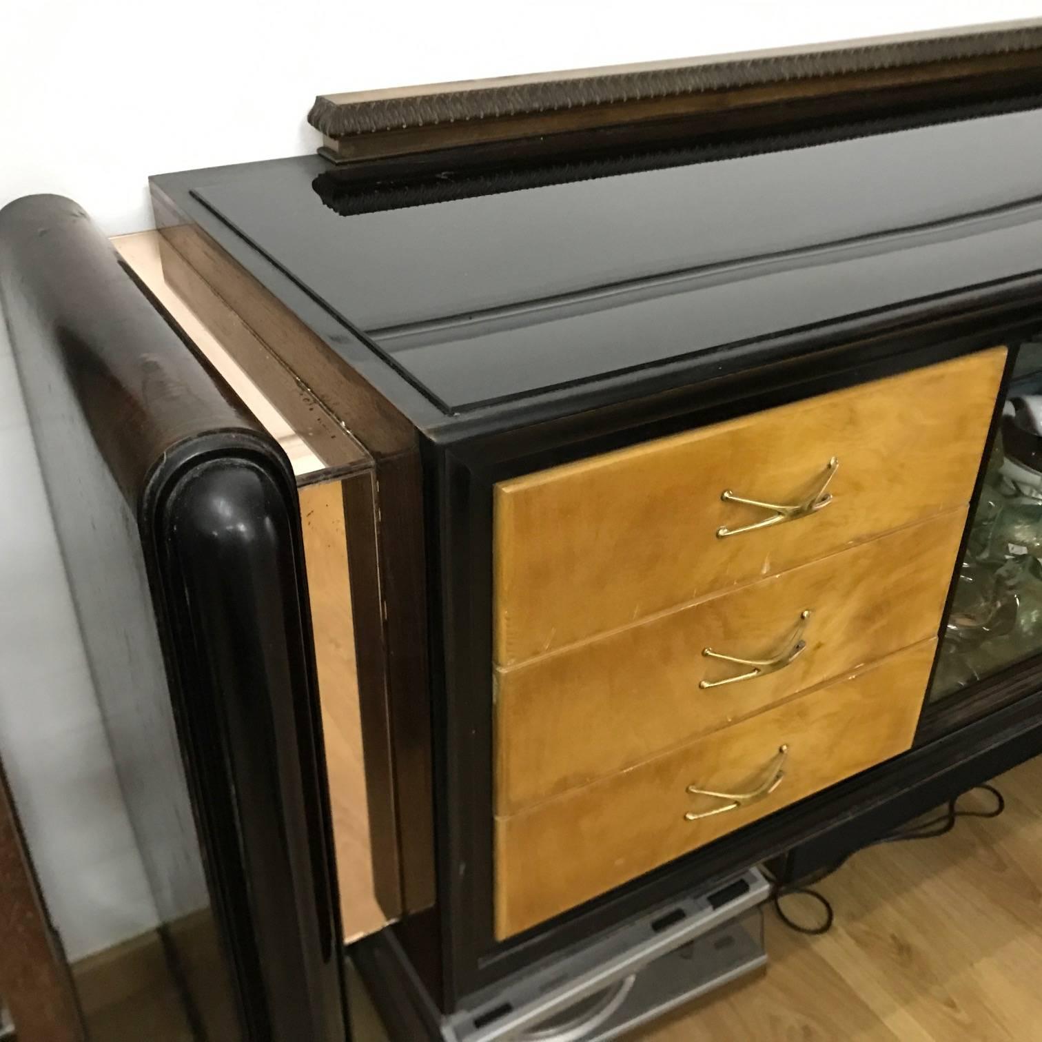 Italian Art Deco sideboard made in Como Northern Italy in the 1920s, three kind of wood, mahogany, maple and black painted wood, pink glass mirror inserts on the sides, black glass on the top, etched glass on the front.
This sideboard features a