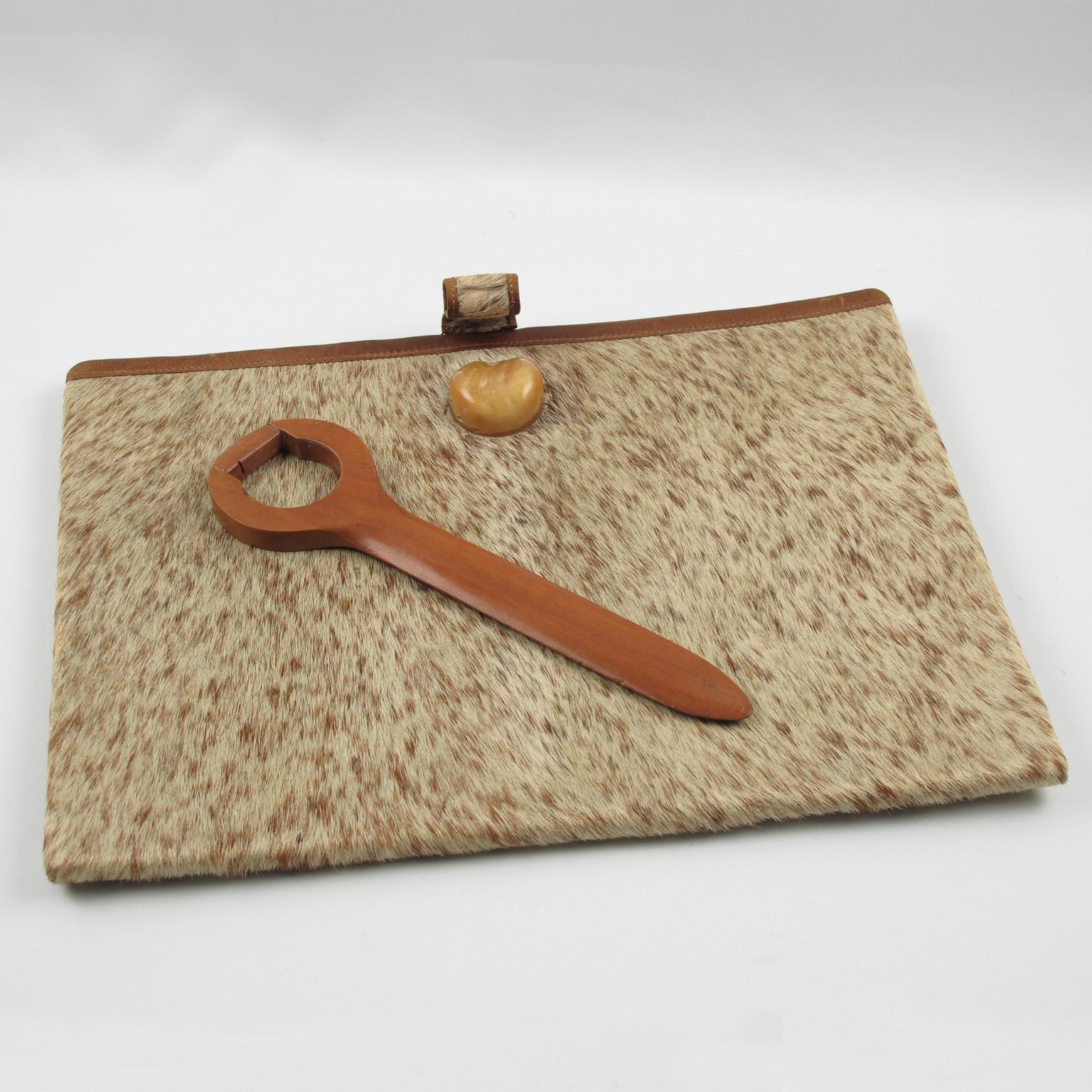 This exquisite desk set by Dan Karner, also known as Daniel Karner, showcases the beauty of French Art Deco design. Crafted with genuine pony skin fur, rich cognac leather, intricately carved wood, and sparkling crystal, these elegant desktop