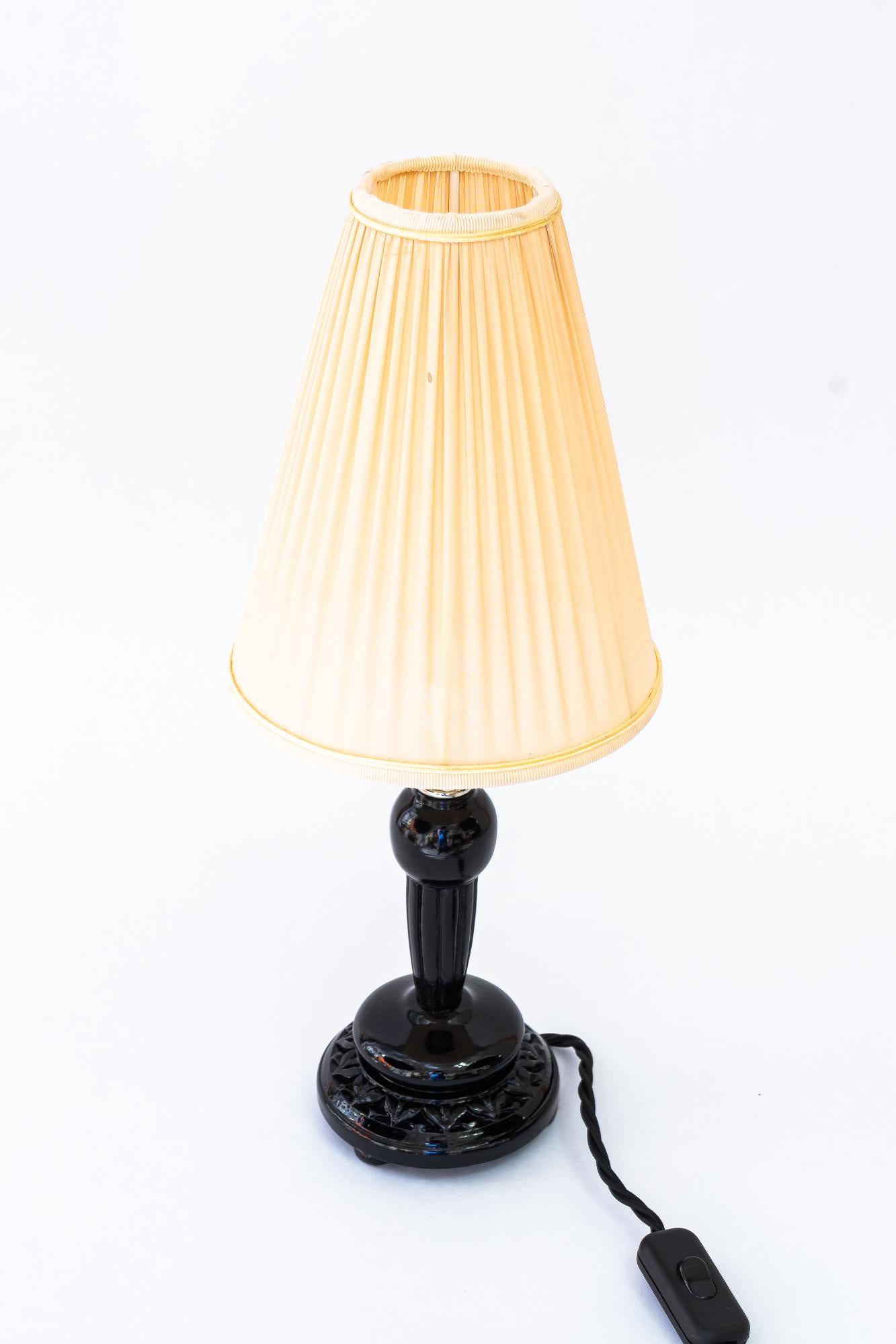 Lampe de table Art Déco et abat-jour en tissu vienne des années 1920
Bois noirci
L'abat-jour en tissu est remplacé (neuf).
Laiton nickelé