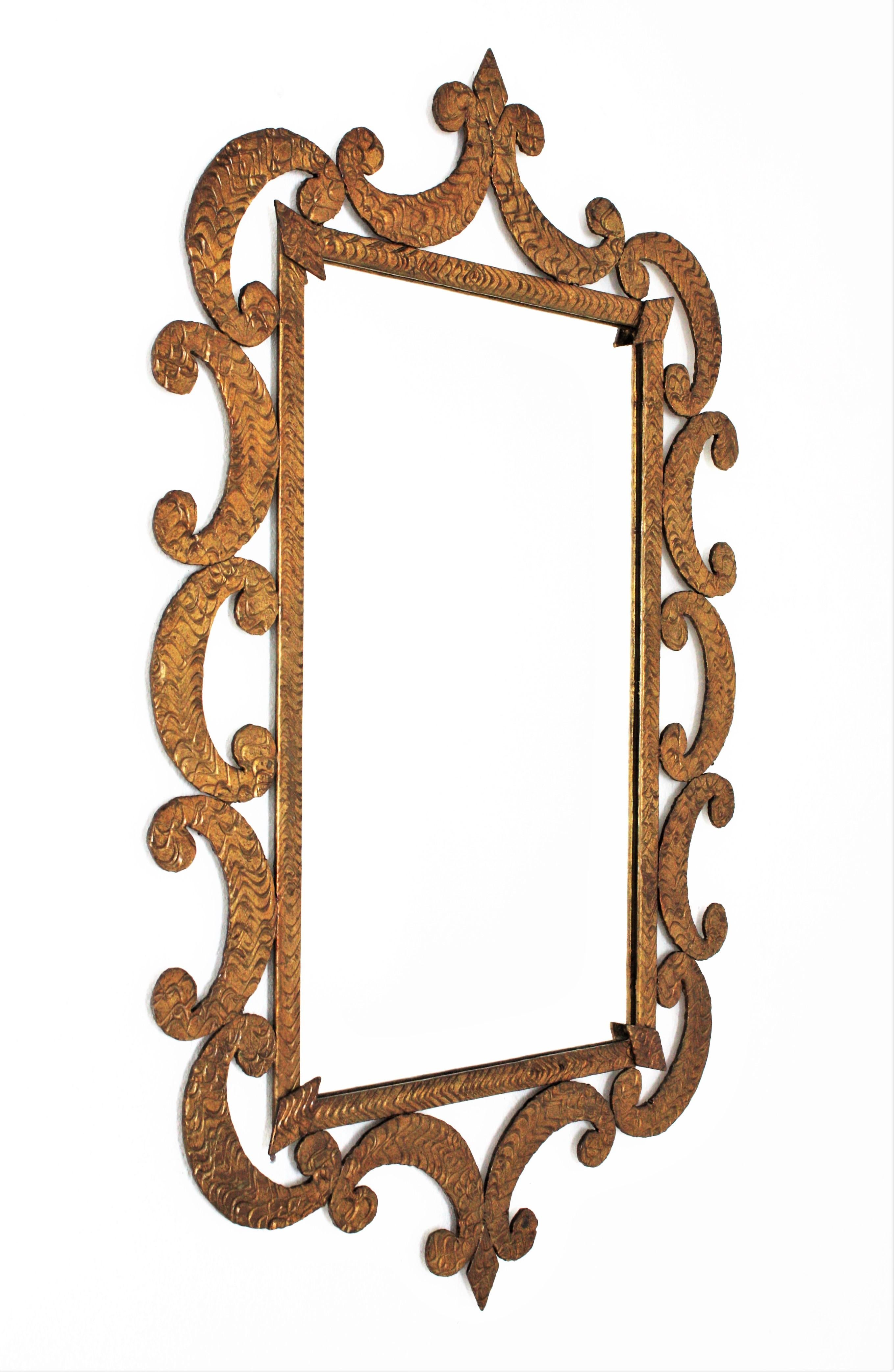 Elegant hand forged gilded iron frame with scroll decorations and rhombus accents at the corners. France, 1930s
This gorgeous mirror has reminiscences from Raymond Subes and Gilbert Poillerat designs.
It has an aged original patina finished in