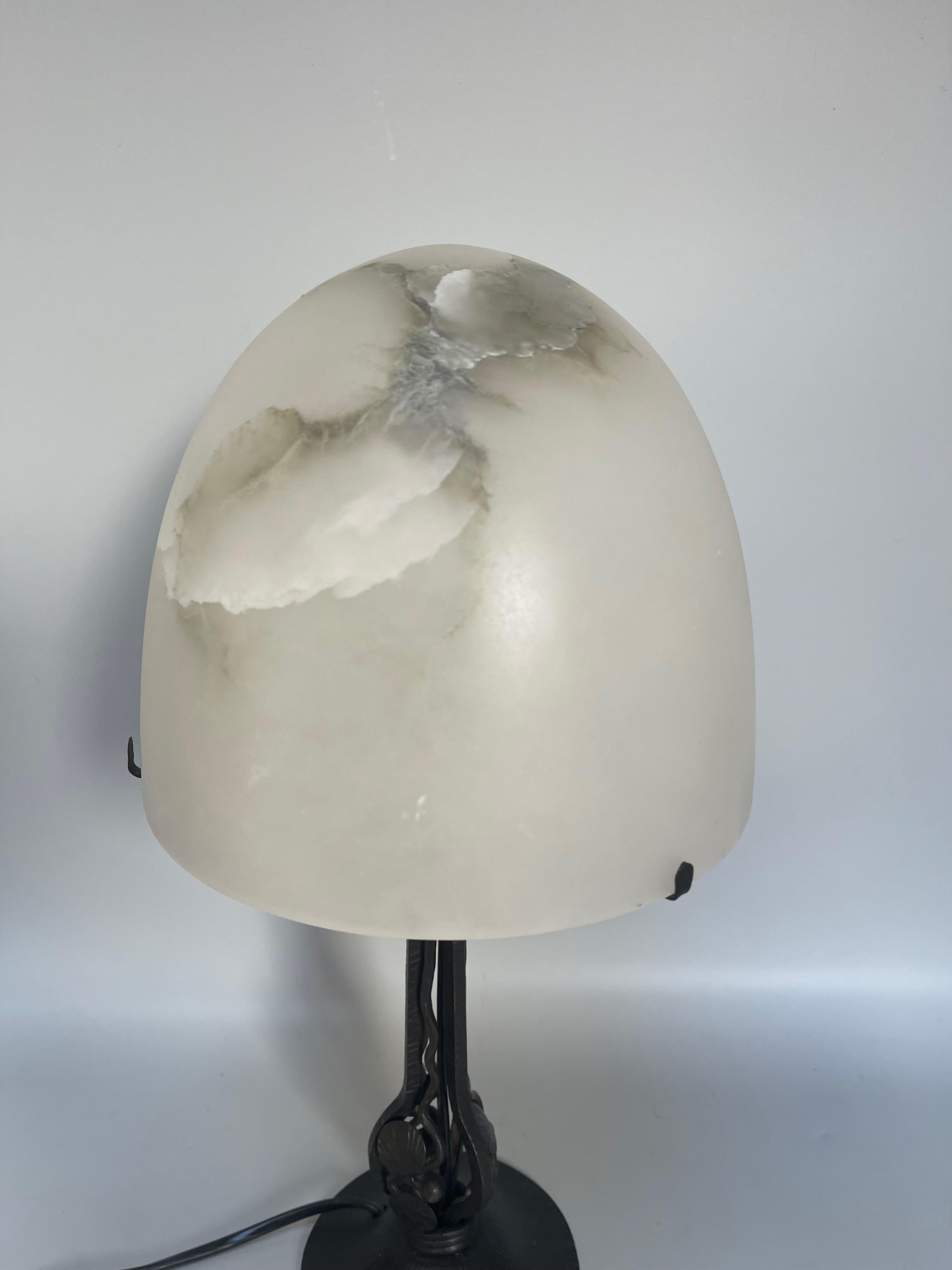 Art deco lamp circa 1930 the base is in wrought iron decorated with a pope shell in alabaster. 
Electrified and in perfect condition.

Diameter: shell 20 cm base 11.5 cm
Height: 40 cm
Weight: 2,7 KG