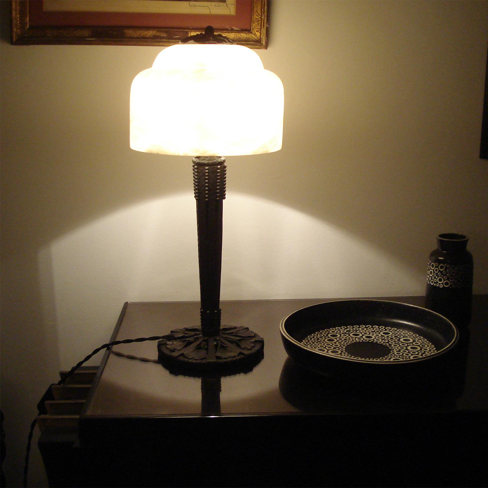 This wrought iron table lamp with a ginkgo leaf design, created by Edgar Brandt, includes an alabaster shade and is marked with Brandt's signature on the foot. It is equipped with an E27 bulb base, appropriate for use in the United States