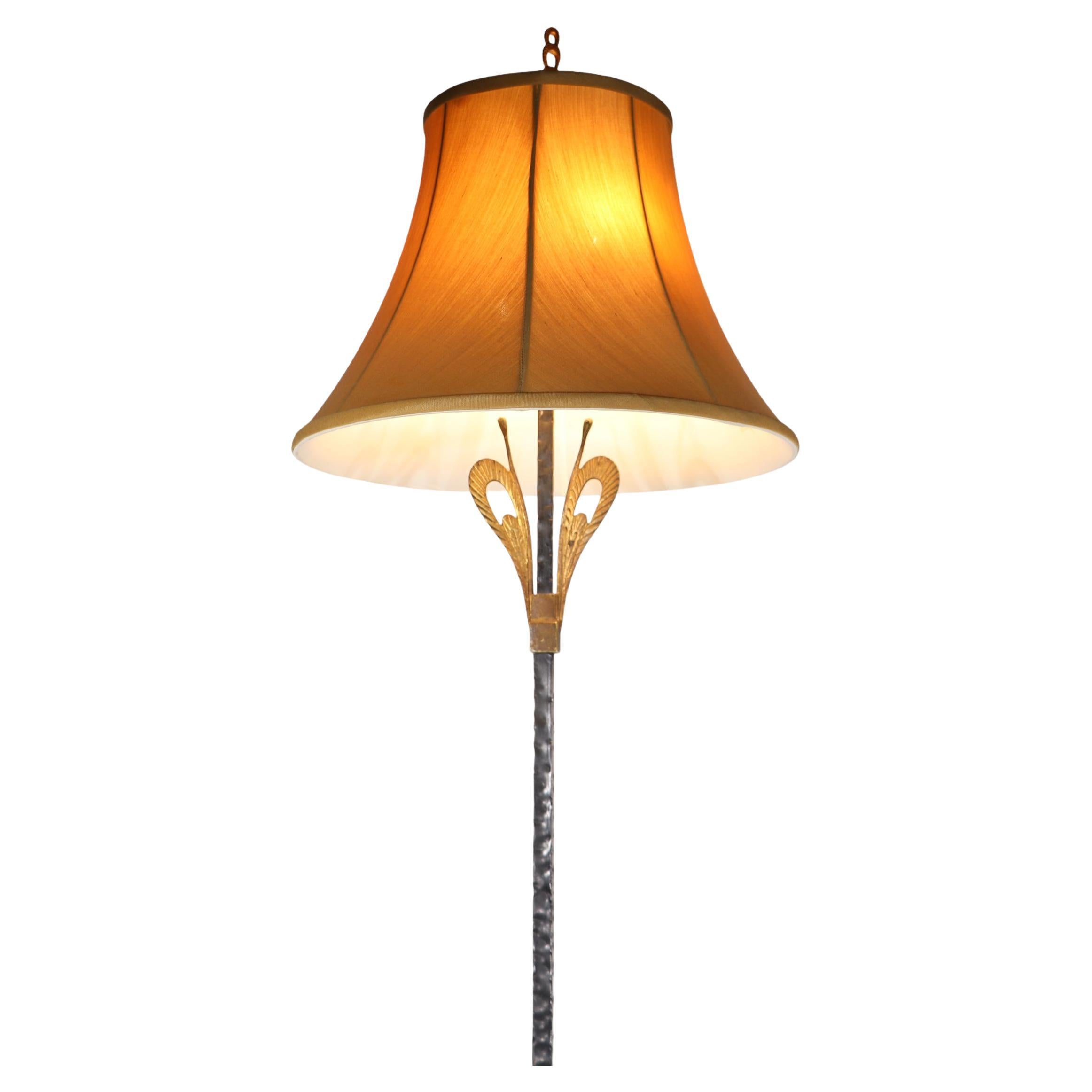 Classic Art Deco flor lamp having a hammered metal vertical shaft, with a stylized hammered iron base, with a brass foliate decorative element at the top of the central vertical standard. Executed in the style of Edgar Brandt, and Oscar Bach, the