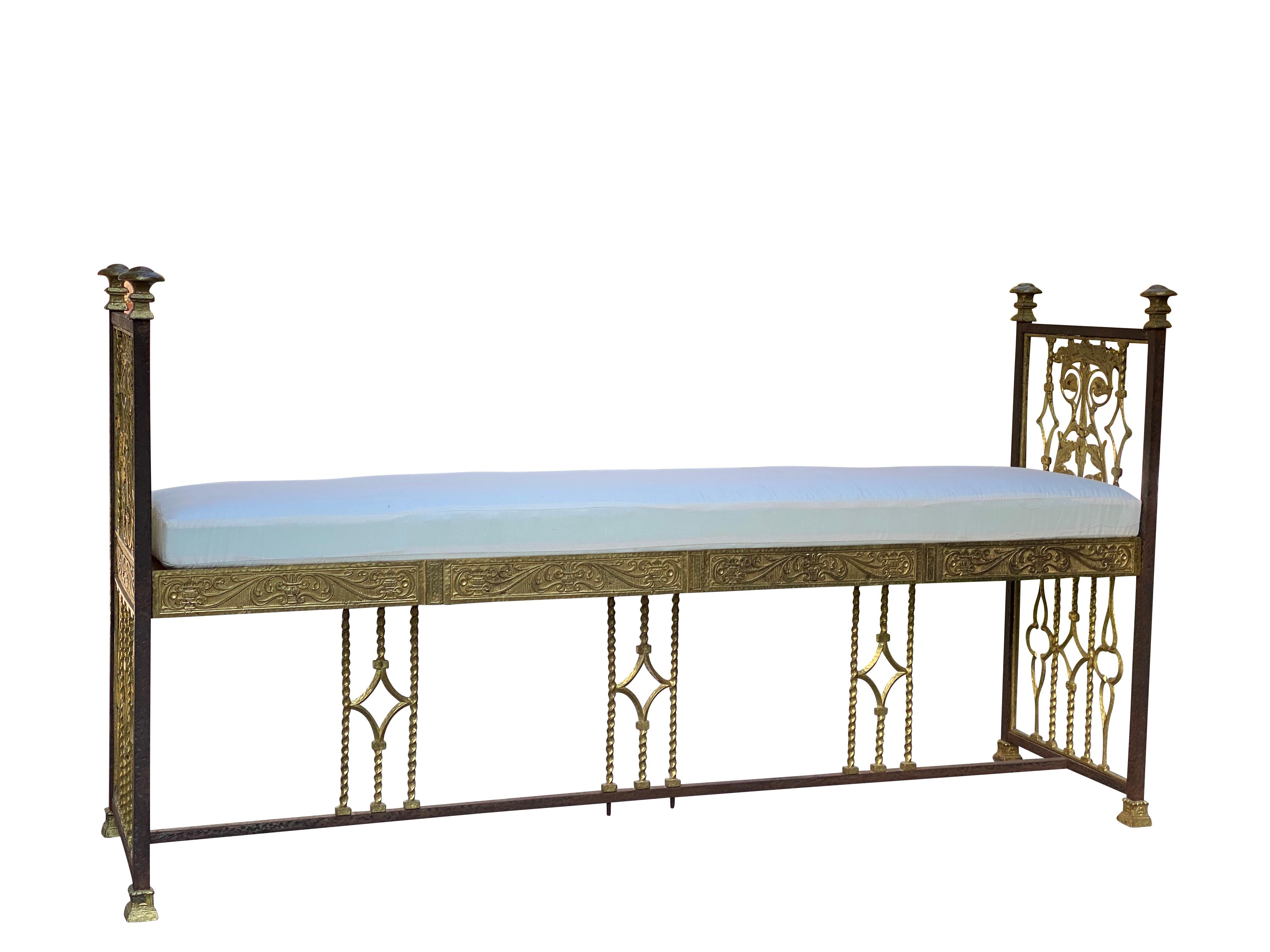 Attributed to Oscar Bach. The ends with brass finials over decorative bronze splat, loose cushion seat, H form stretcher with gothic quatrifoil and diamond decoration.