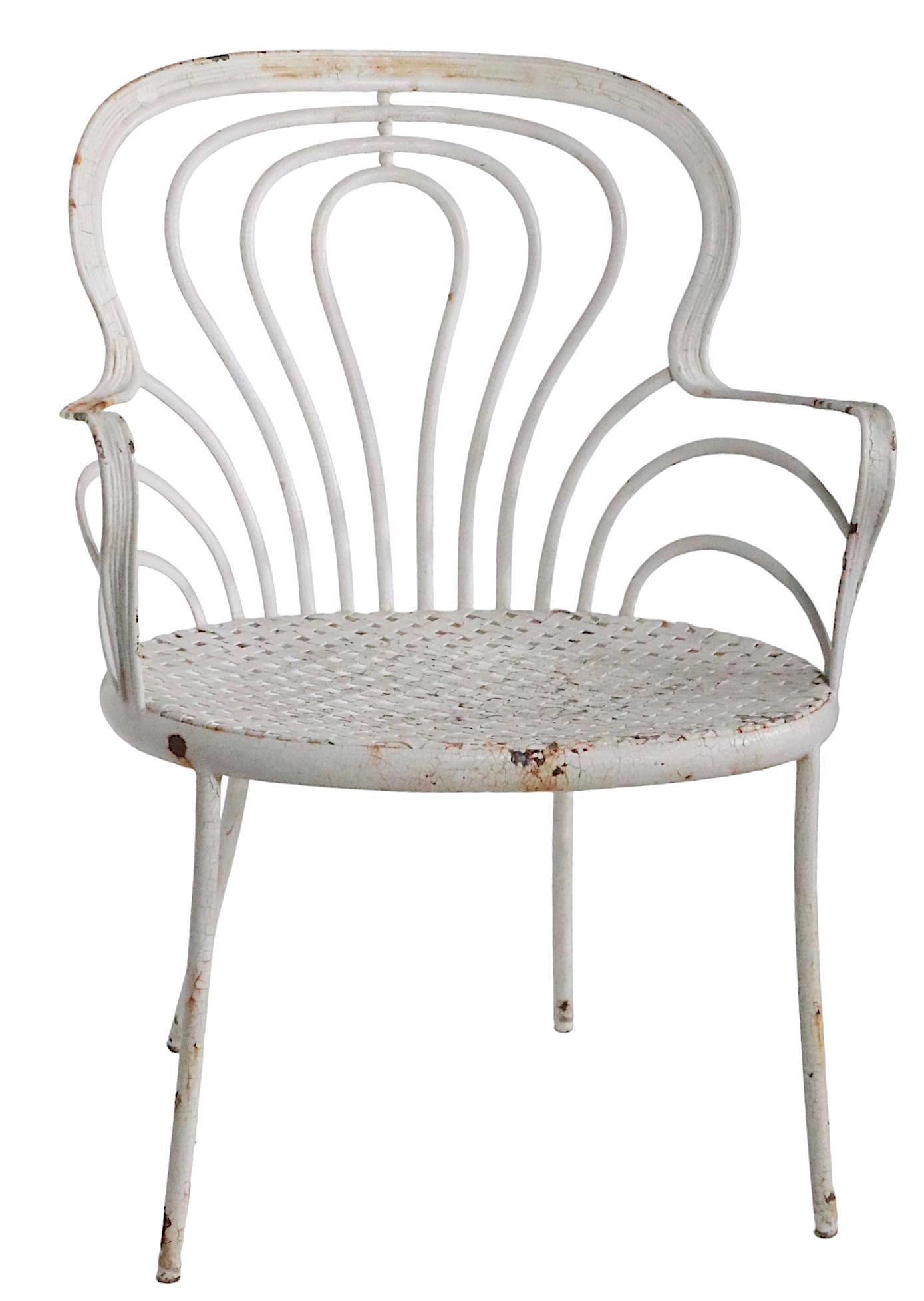 Rare example of the work of connoisseur garden furniture maker, Leinfelder. The chair features a lyrical, organic curved cab and arm rests, with a woven style seat on solid iron legs. In addition to being tres chic, the chair is unexpectedly