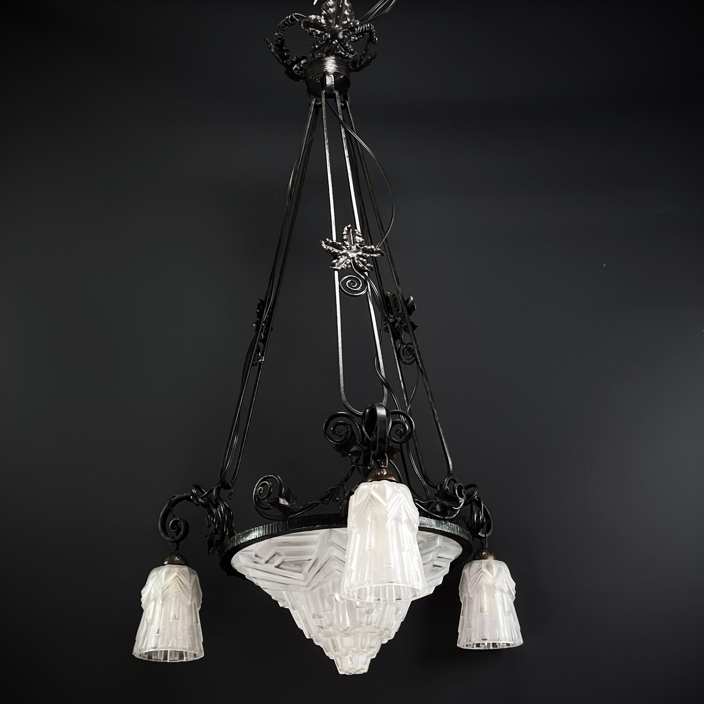 Art Deco chandelier - 1930s

The ART DECO ceiling lamp is a fascinating example of the masterful craftsmanship and exquisite design of this manufactory. This ceiling lamp skillfully combines the charm of the Art Deco style with the beauty of wrought