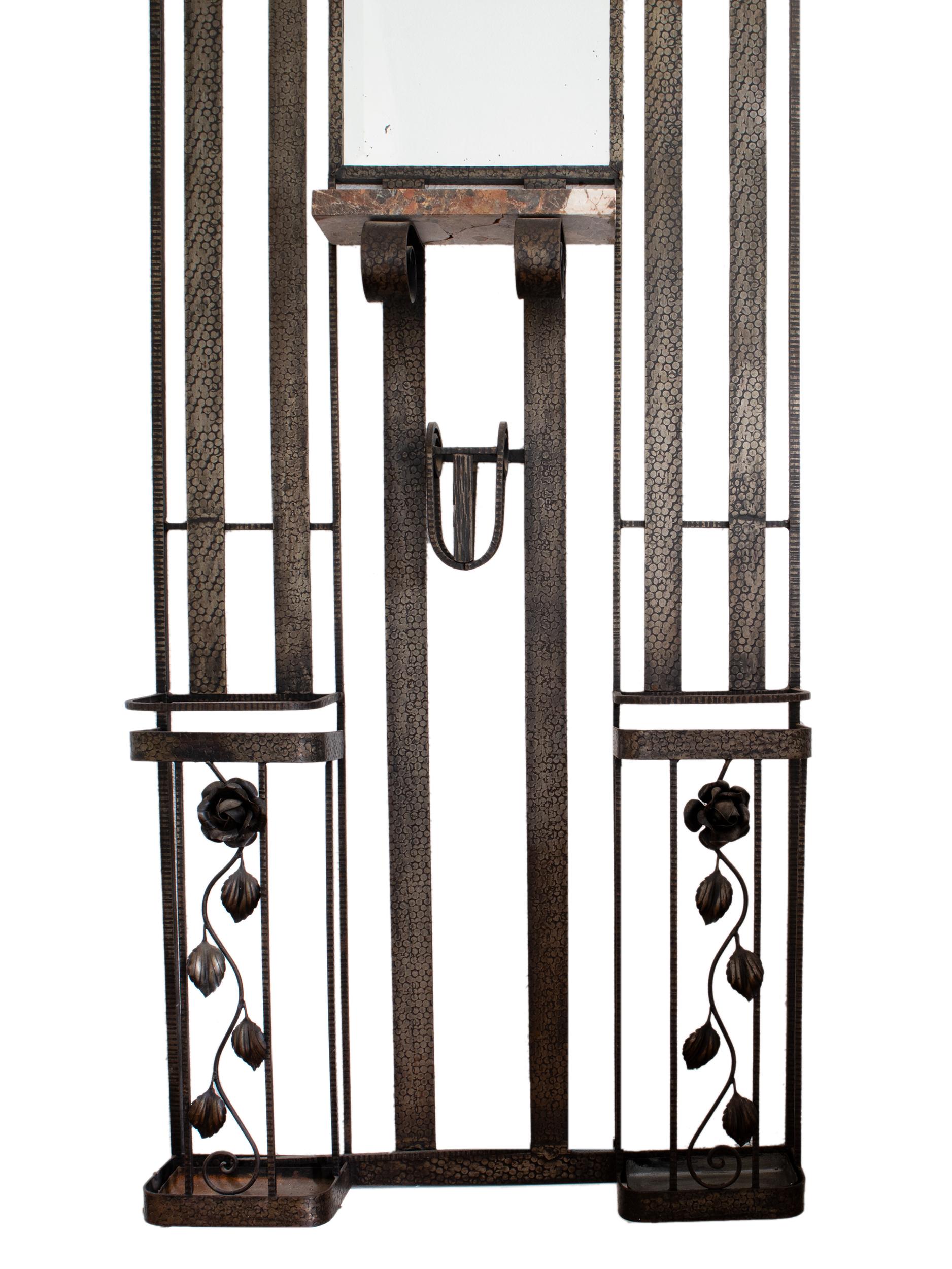 A 1930s French Art Deco wrought iron foyer coat rack or hall tree.
Wonderfully decorated with geometric and circular iron work, two electrified lights with round frosted glass cover, an overhead shelf, four coat hooks, two umbrella stand or holder,
