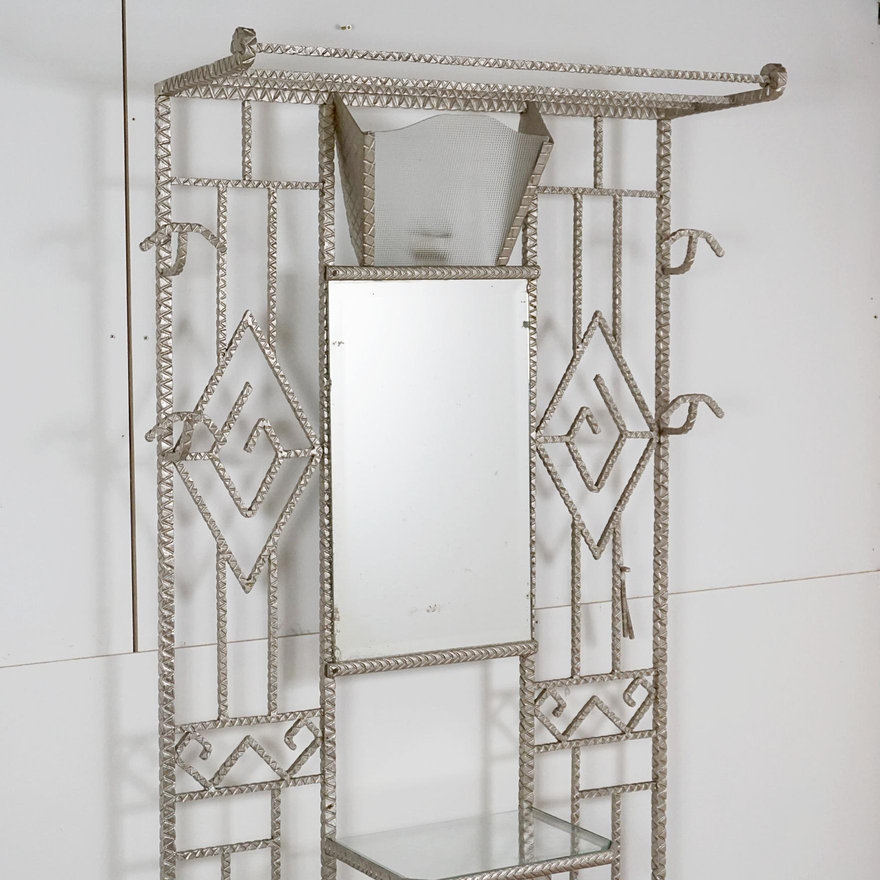 Meuble d'entrée en fer forgé de style Art déco. Miroir central en console avec deux porte-baguettes de part et d'autre, porte-manteau et porte-chapeau. 