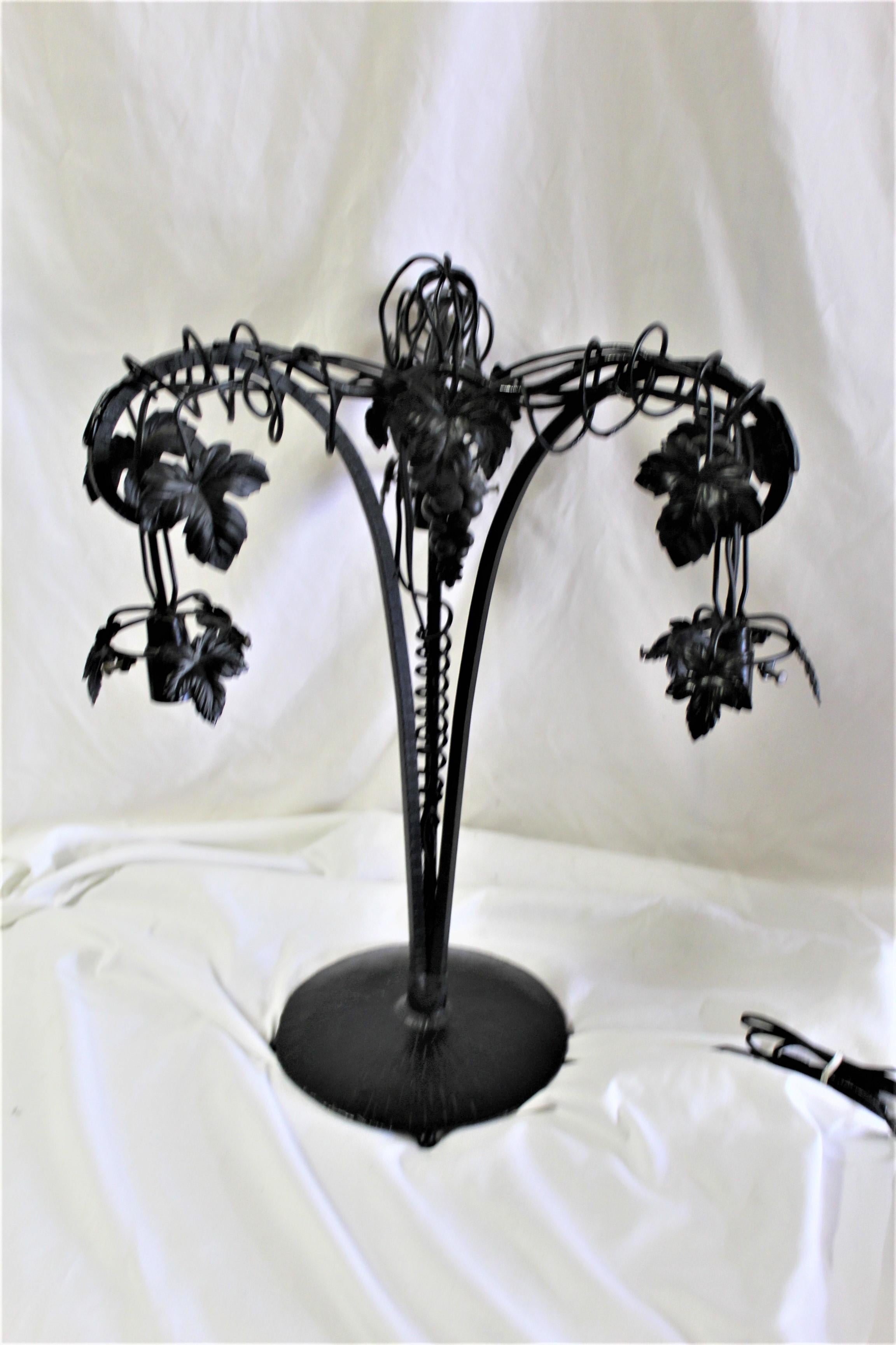 All hand forged iron metal base in the grape vine design from the E.Brandt design. With 3 French art glass shades from Vianne. Base is finished in semi-black painted finish. Total ht is at 22