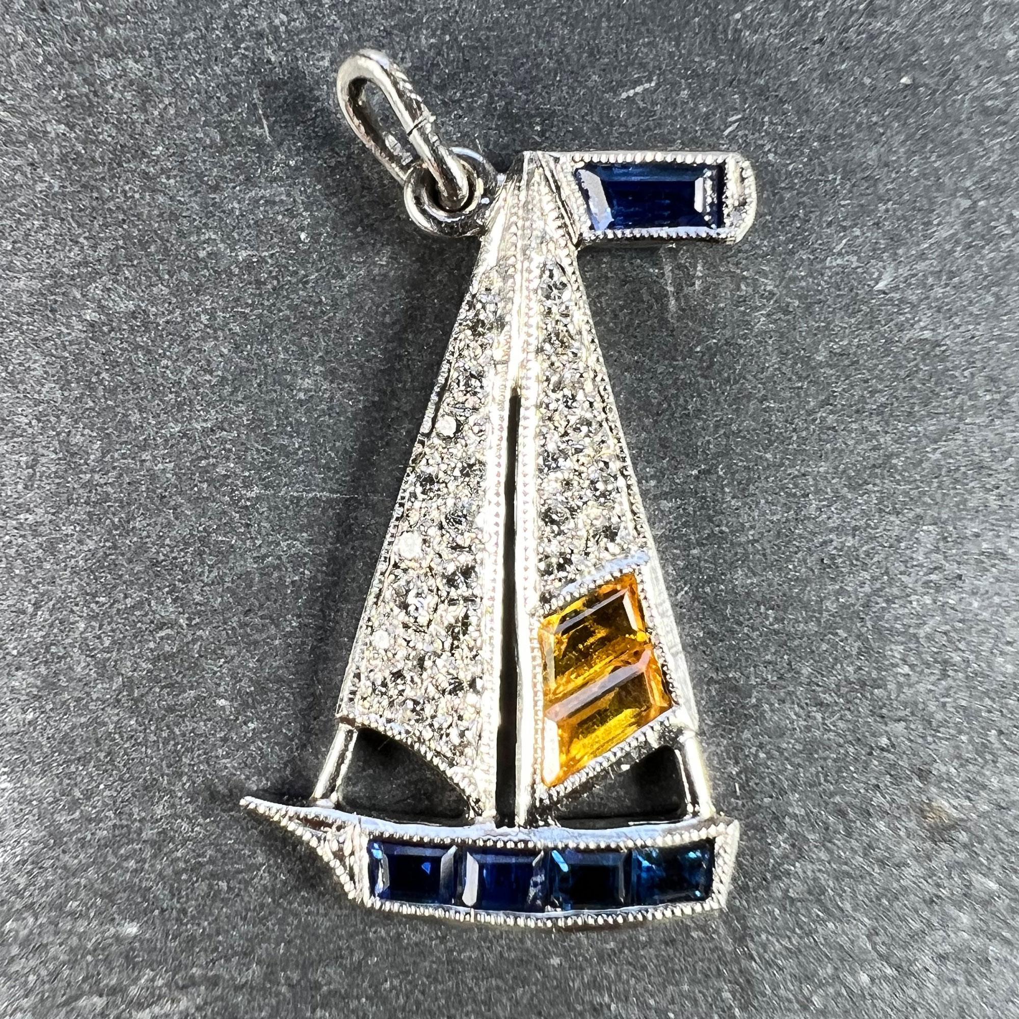 An Art Deco platinum charm pendant designed as a sailing yacht or sailboat with diamond and citrine sails on a sapphire boat. The charm is set with 25 round brilliant cut diamonds, two trap-cut citrines and five emerald-cut sapphires. Unmarked but