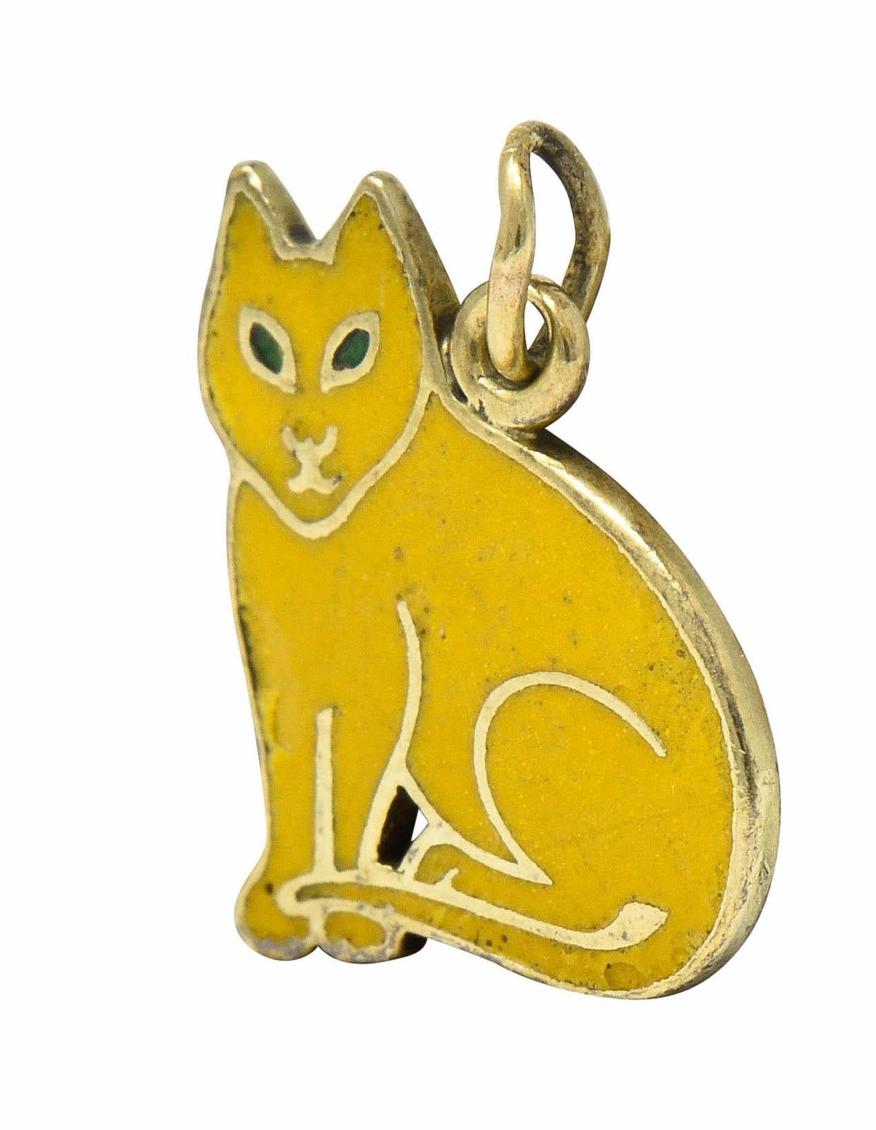 Charm is designed as a stylized cat glossed with yellow enamel, exhibiting minimal loss

With a pointed face and bright green enamel eyes

Depiction is featured on both sides of charm

Tested as 14 karat gold

Circa: 1930

Measures: 3/8 x 1/2