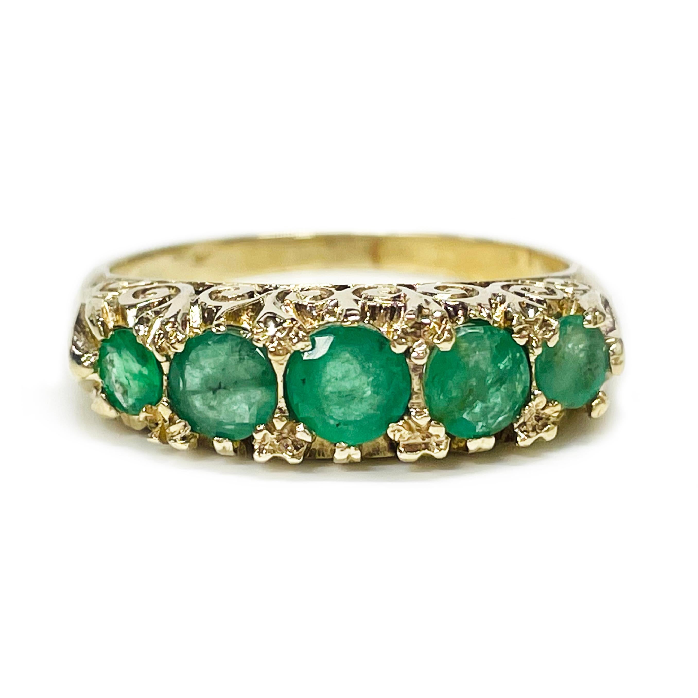 Art Deco 14 Karat Yellow Gold Emerald Ring. This original lovely ring features five round emeralds prong-set in a raised gallery. There are three 4.7mm emeralds and two 3.3mm emeralds. The ring has gold filigree scroll details on both sides of the