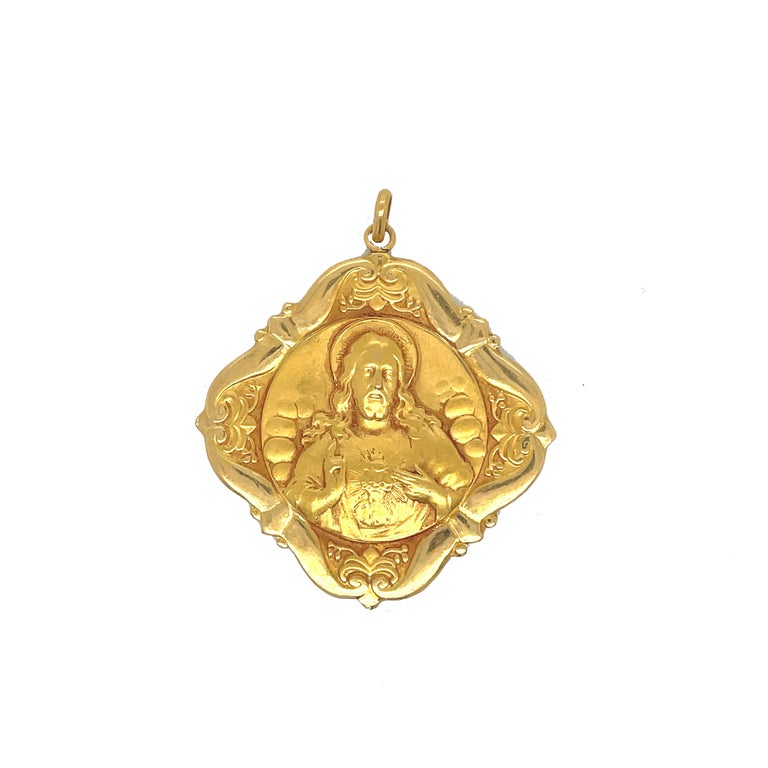 This is an absolutely stunning 1940s pendant set in 18K Yellow Gold that features a gorgeous engraved depiction of the sacred heart and mother and child. The intricate attention to detail and craftsmanship of this pendant is exquisite. The lovely