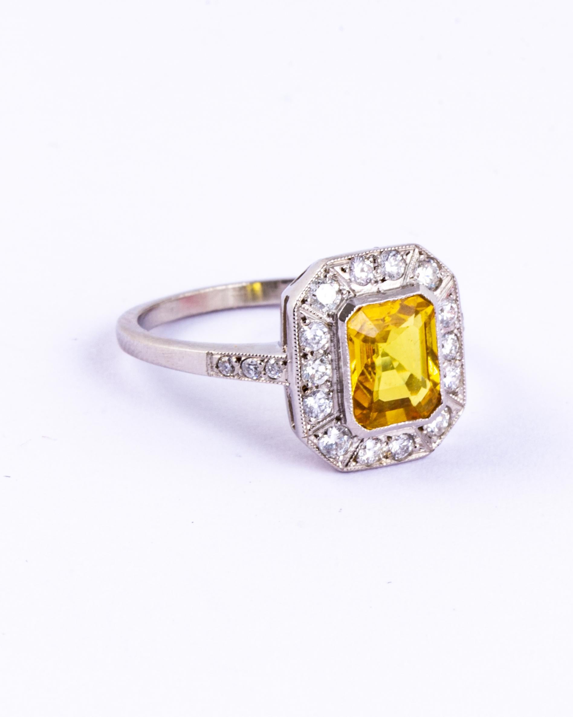 This stunning cluster ring holds a bright yellow sapphire at the centre and is surrounded by glistening diamonds. The sapphire measures approx 1.5carat and the brilliant cut diamonds total approx 70pts including the shoulders. Modelled in platinum.