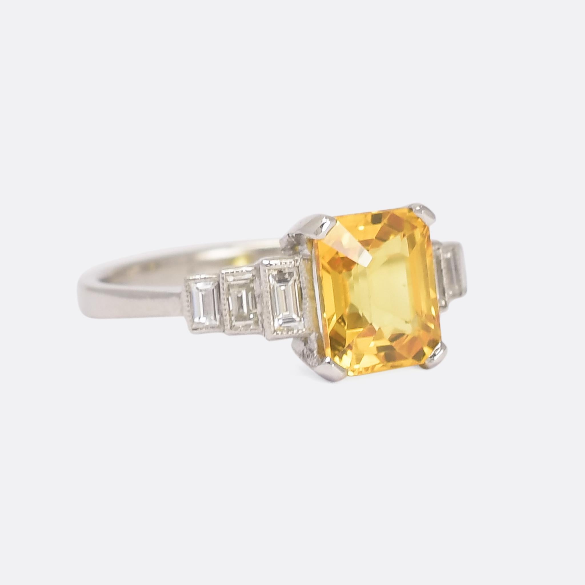 A magnificent Art Deco cocktail ring set with a 2.5 carat emerald cut yellow sapphire flanked by stepped baguette diamond shoulders. It's quintessentially Deco in style, modelled in platinum throughout with bold use of colour and diamonds resting in