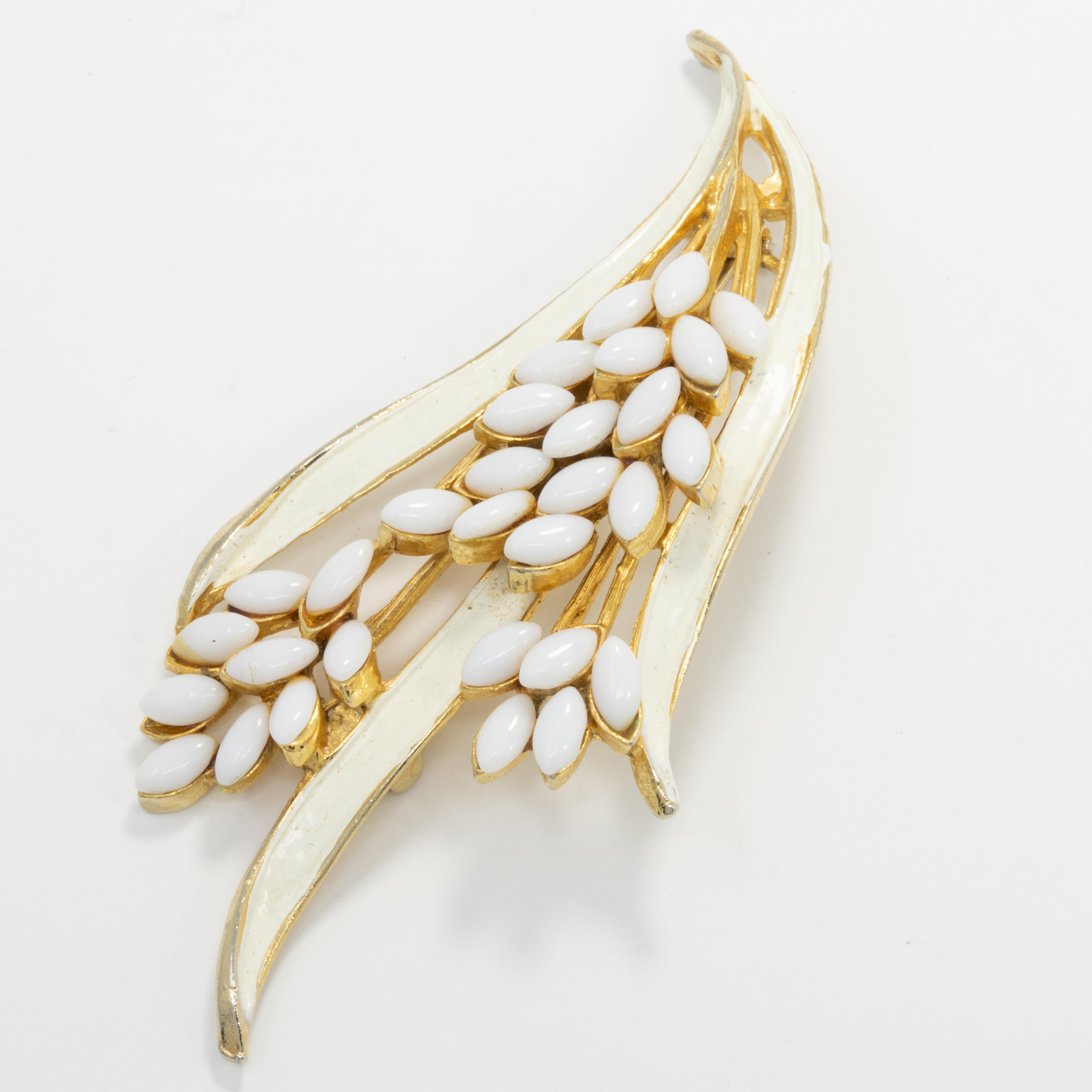 An elegant floral bouquet, the perfect accent for any style! Golden vintage pin brooch by Arthur Pepper, featuring white enamel leaves and white glass cabochon petals.

Gold-plated.

Marks / hallmarks / etc: Art
