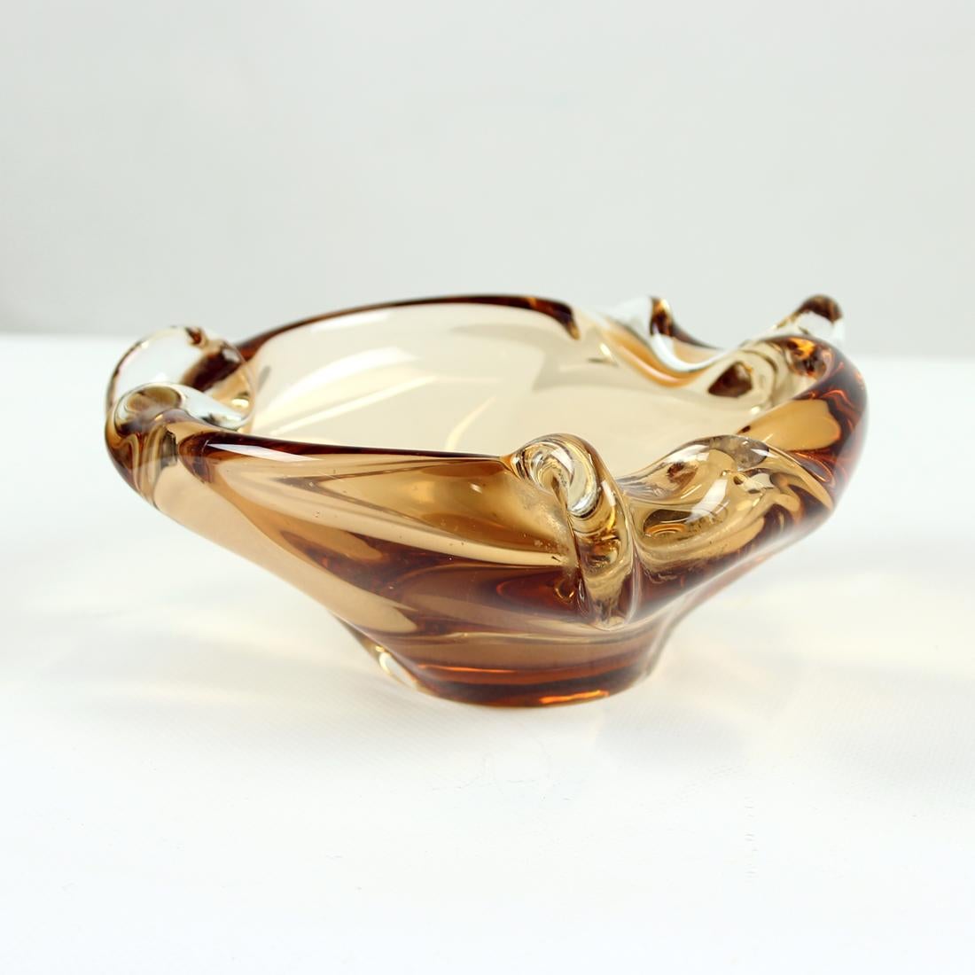 Beautiful smaller bowl made of moulded art glass. Designed by Jan Beranek for Skrdlovice in Czechoslovakia. The designer was well known for his amazing art work with glass. This piece is in a combination of amber glass with clear transparent glass.