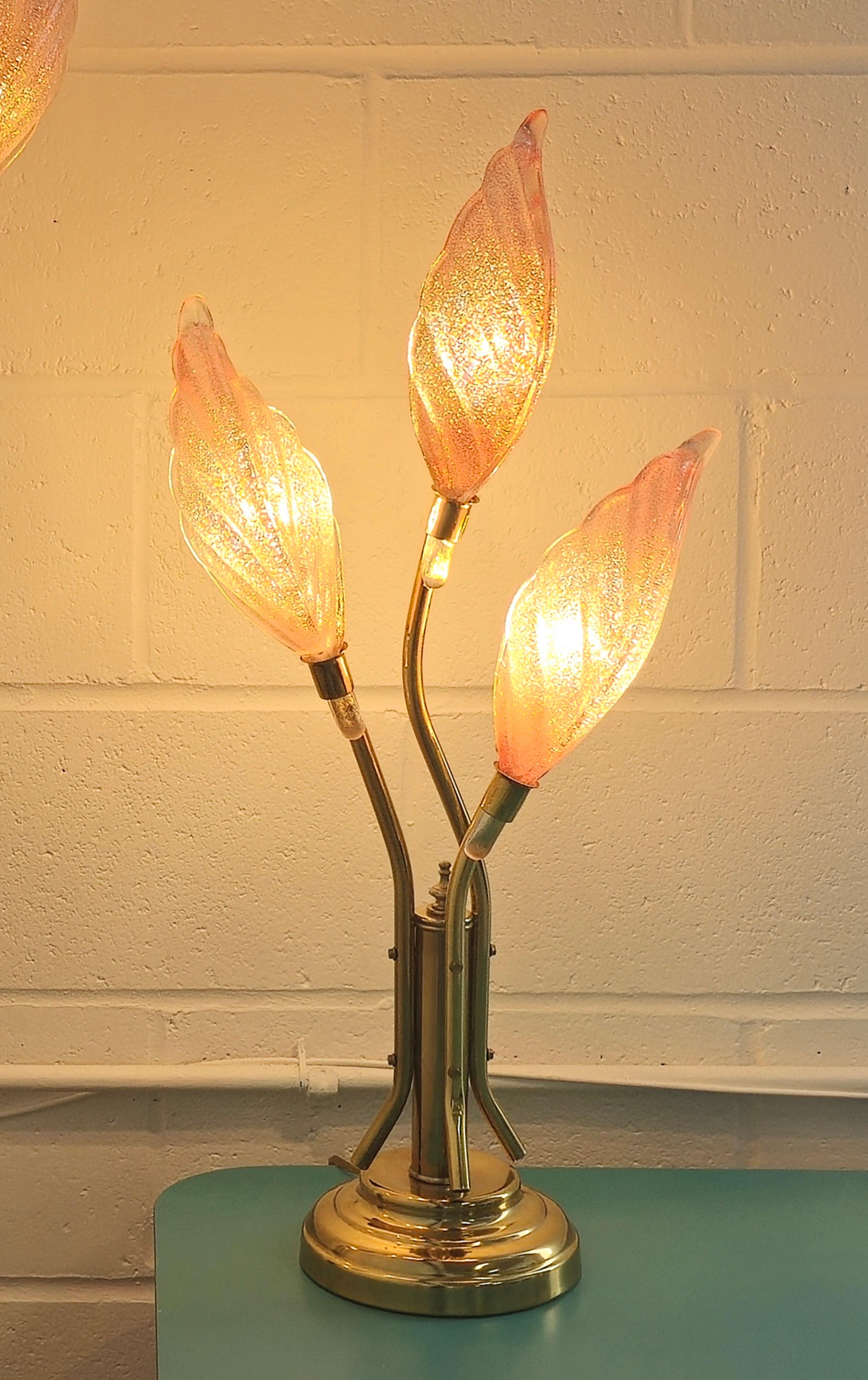 Stunning three tier art glass and brass floral  table lamp from the 1970s. It is reminiscent of hollywood regency design. Crafted with precision, this brass floor lamp features art glass floral shaped shades. Each shade is crafted with art glass in