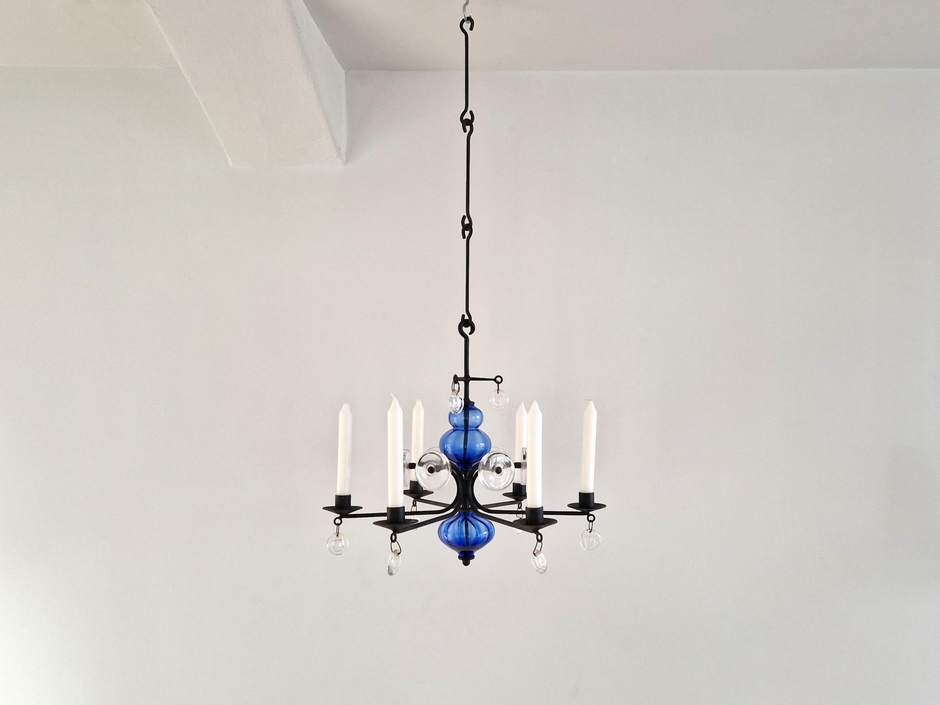 This beautiful blue and clear art glass on wrought iron candelabra chandelier was designed by Erik Höglund for Boda Glasbruk & Smide. Höglund (1932–1998) was one of the brightest stars of 20th-century Swedish glass design. This 6 arm chandelier is