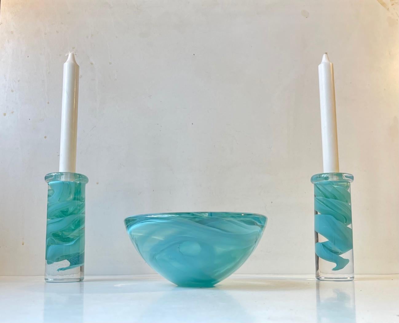 Thick and heavy conical art glass bow and two matching candlesticks from Kosta Boda in Sweden. Designed by Anna Ehrner in the mid 1980s. The technique is called Atoll and it features mint/turqouise swirl-work to the inside the clear glass. Original