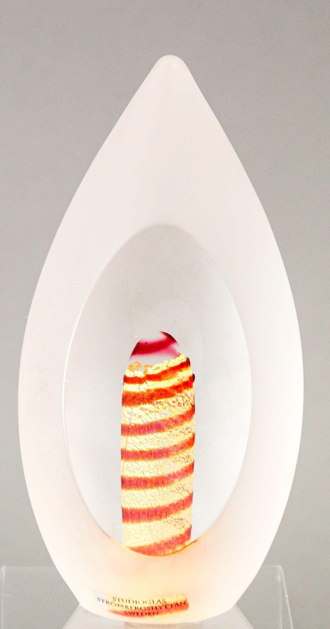 Scandinavian Studioglas Strombergshyttan Sweden 1970s Art Glass Egg Sculpture Paperweight.
This stunning studio art glass piece, signed and numbered, dates back to the 1970s.
It features a transparent, sloped egg shape with frosted sides, except for