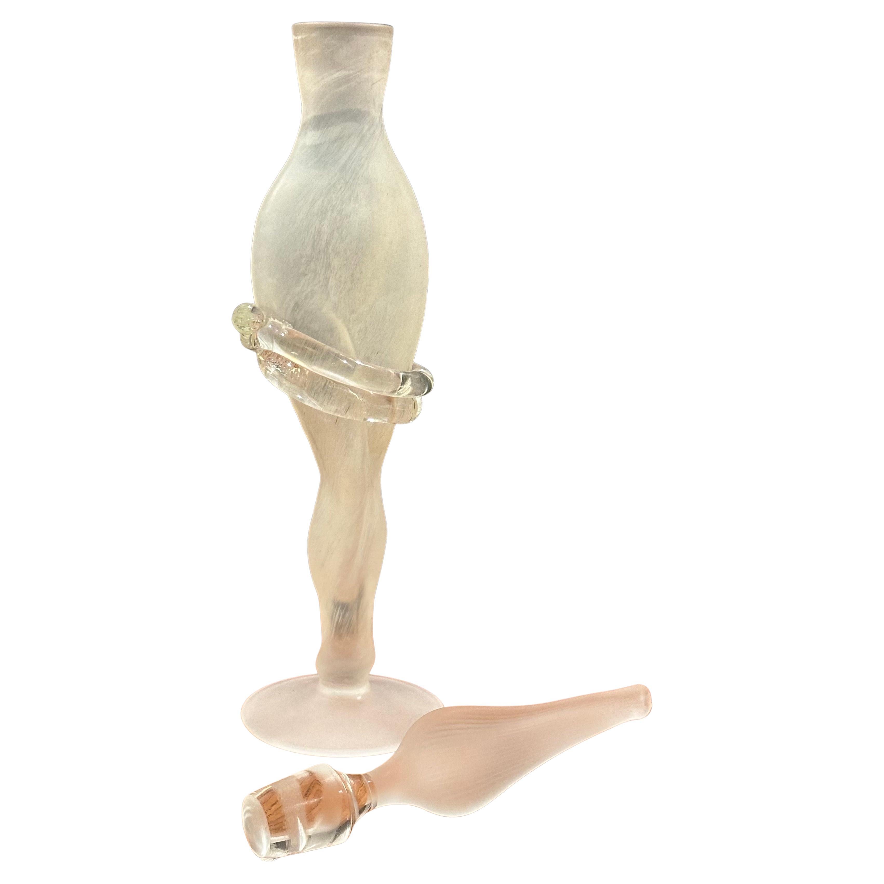 Frasco de perfume figurativo de vidrio artístico con tapón, obra de Elena Graure Manta, hacia la década de 1990. Esta pieza es absolutamente preciosa, con un intrincado físico femenino tallado en cristal.   Está en muy buen estado, sin astillas ni