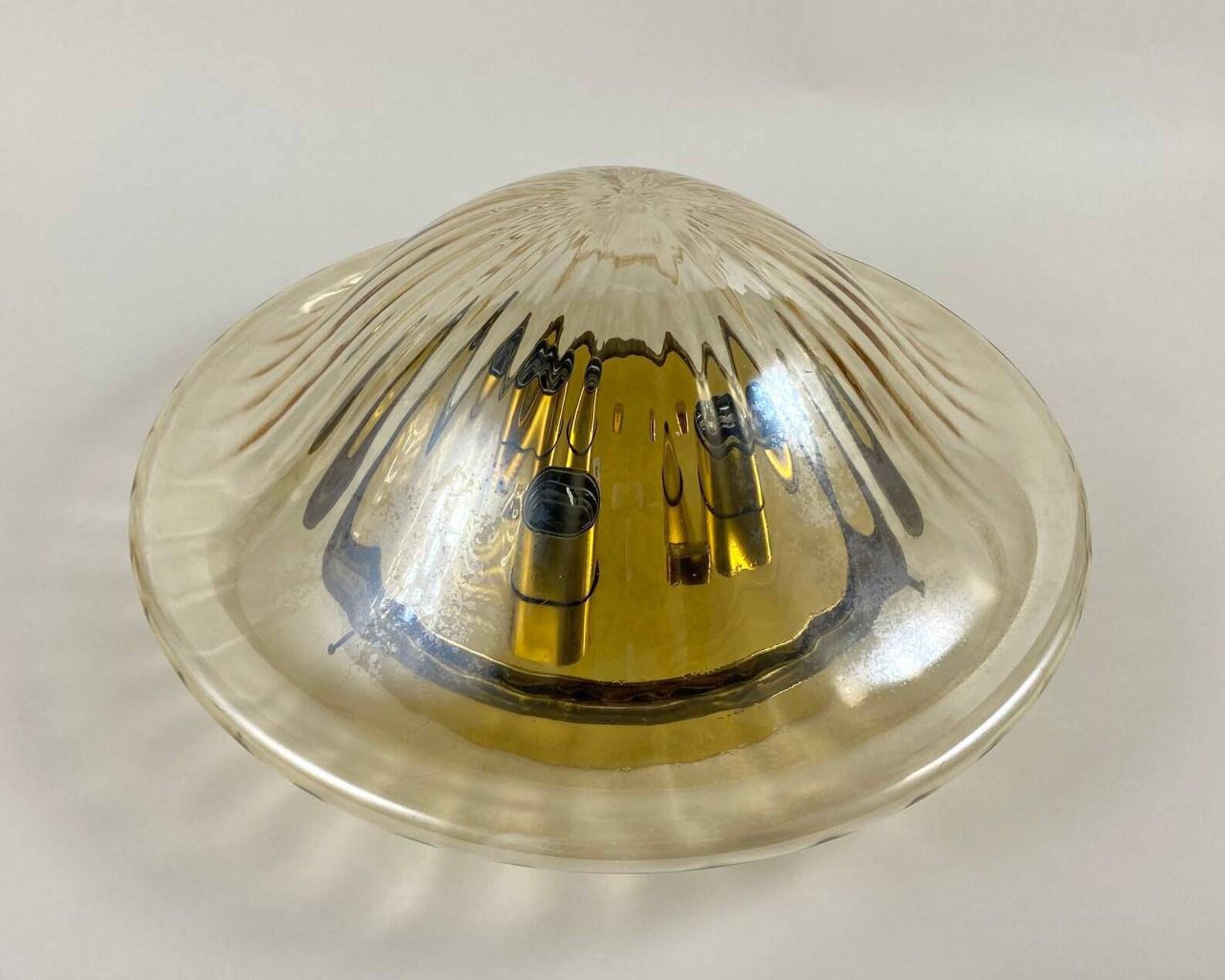 Vintage flush mount chandelier with 3 light points. Corrugated glass shade.

 This chic ceiling lamp has a gilt brass fittings, with a shade of beautiful glass, which sparkles beautifully. 

Directly to the ceiling, a round flush-mounted stand.