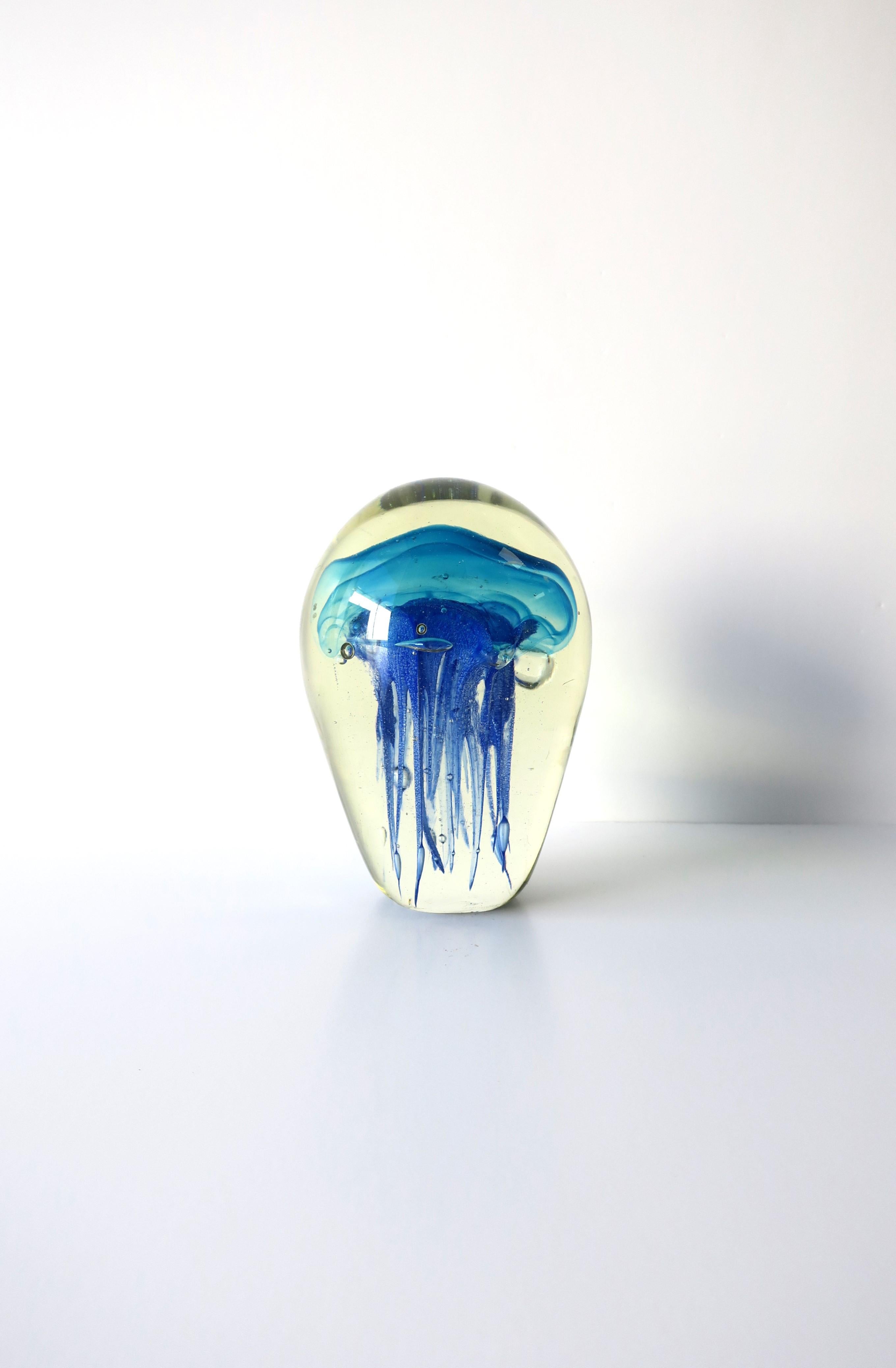 A beautiful and substantial transparent/clear and shades of blue art glass jellyfish sculpture decorative object, circa late-20th century to early 21st century. A great piece to add to any room on a shelf, cocktail table, library, office, etc. Very