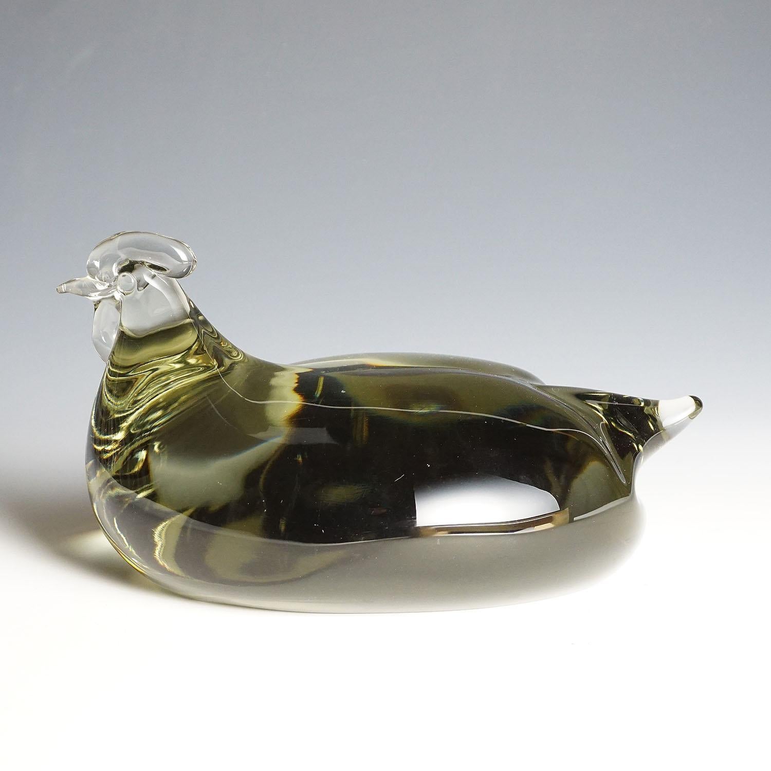 Grande sculpture d'un poulet stylisé en verre gris fumée. Fabriqué à la main dans la manufacture de verre Gral, en Allemagne. Conçu par Livio Seguso, vers 1970. Signature incisée de l'artiste (LS) sur la base.

Livio Seguso (* 1930) est issu d'une