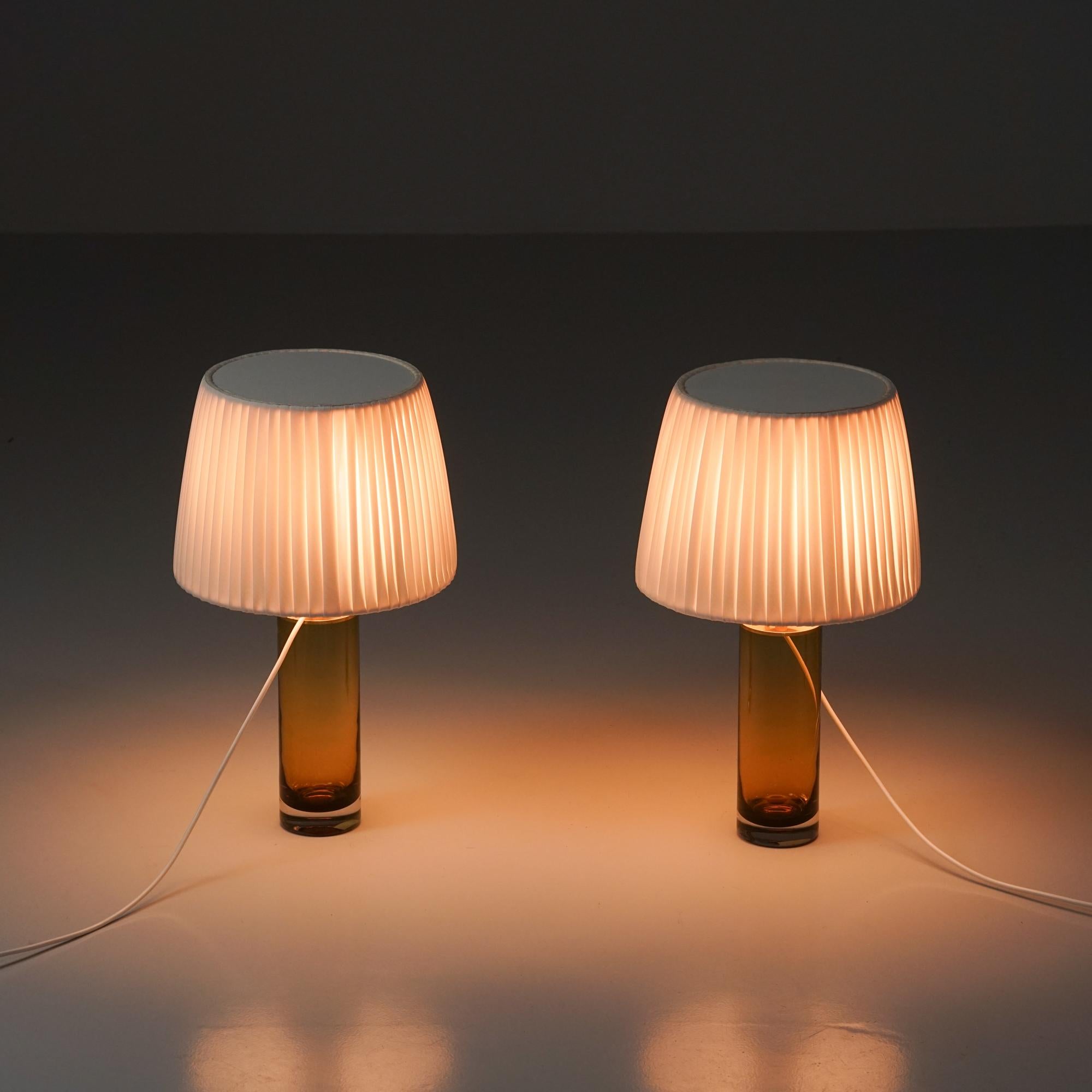 Lámparas de mesa de vidrio artístico, fabricadas en Suecia, años 60. Marco de cristal con detalles de latón, pantallas de tela hechas a mano. Buen estado vintage, pátina menor acorde con la edad y el uso. 