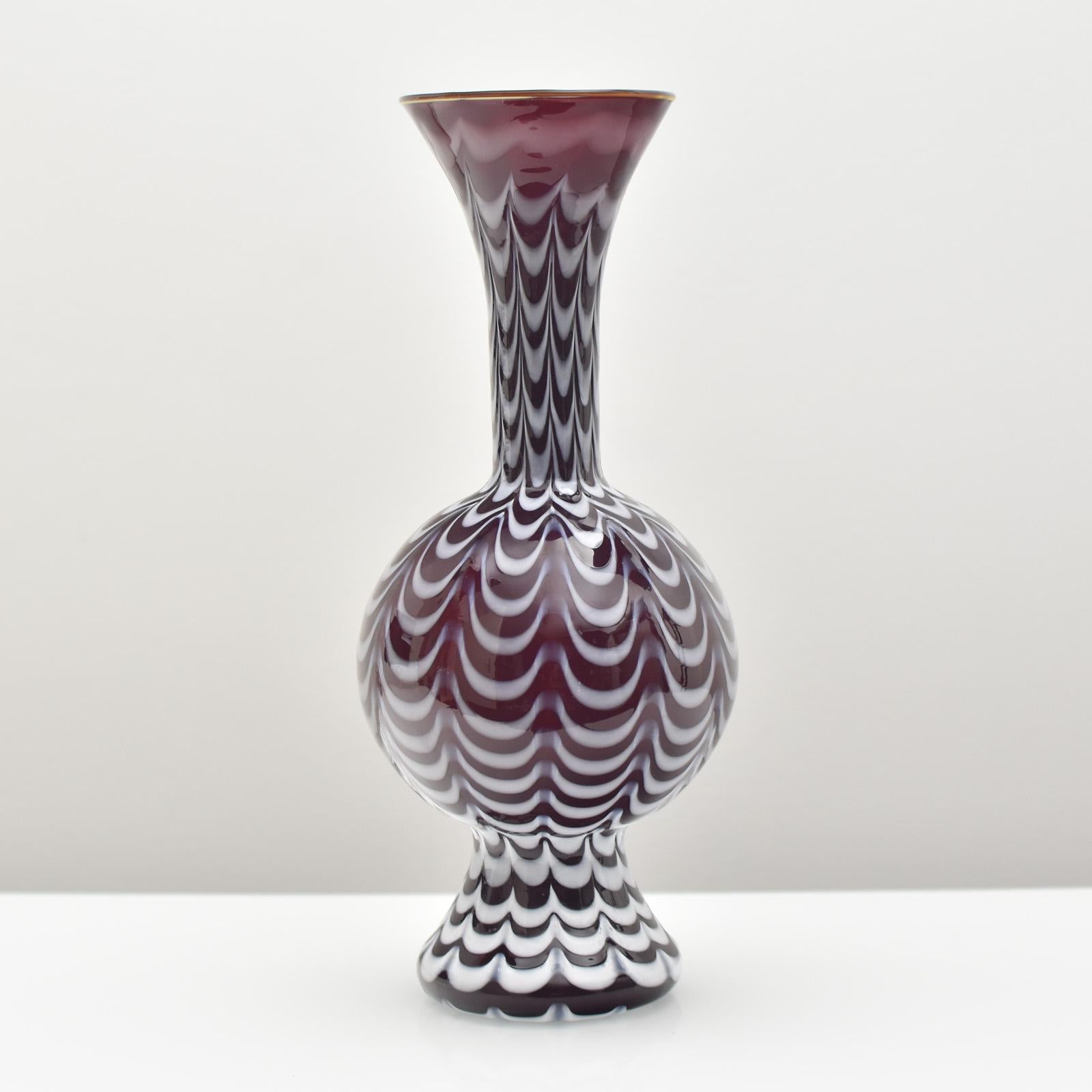 This is a large and elegant vintage Fenicio art glass vase made by Fratelli Toso around 1940. The vase is crafted from high-quality glass and features a stunning deep ruby red color with white accents. The Fenicio technique used in creating this