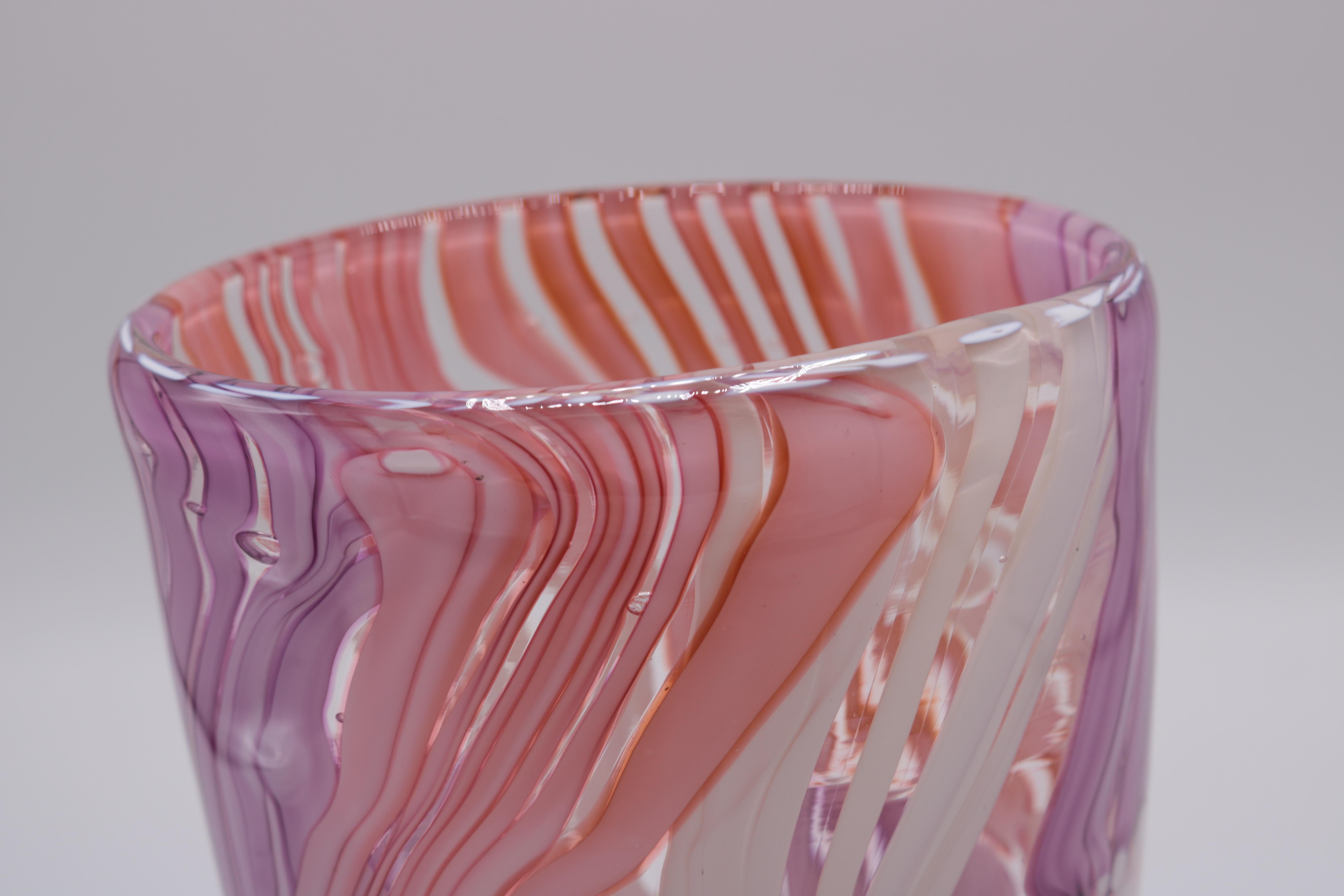 Vaso in vetro artistico in edizione limitata di Martin Postch. 
Vetro trasparente di forma ovale con dettagli rosa, bianchi e viola. 
Firma incisa sul fondo.