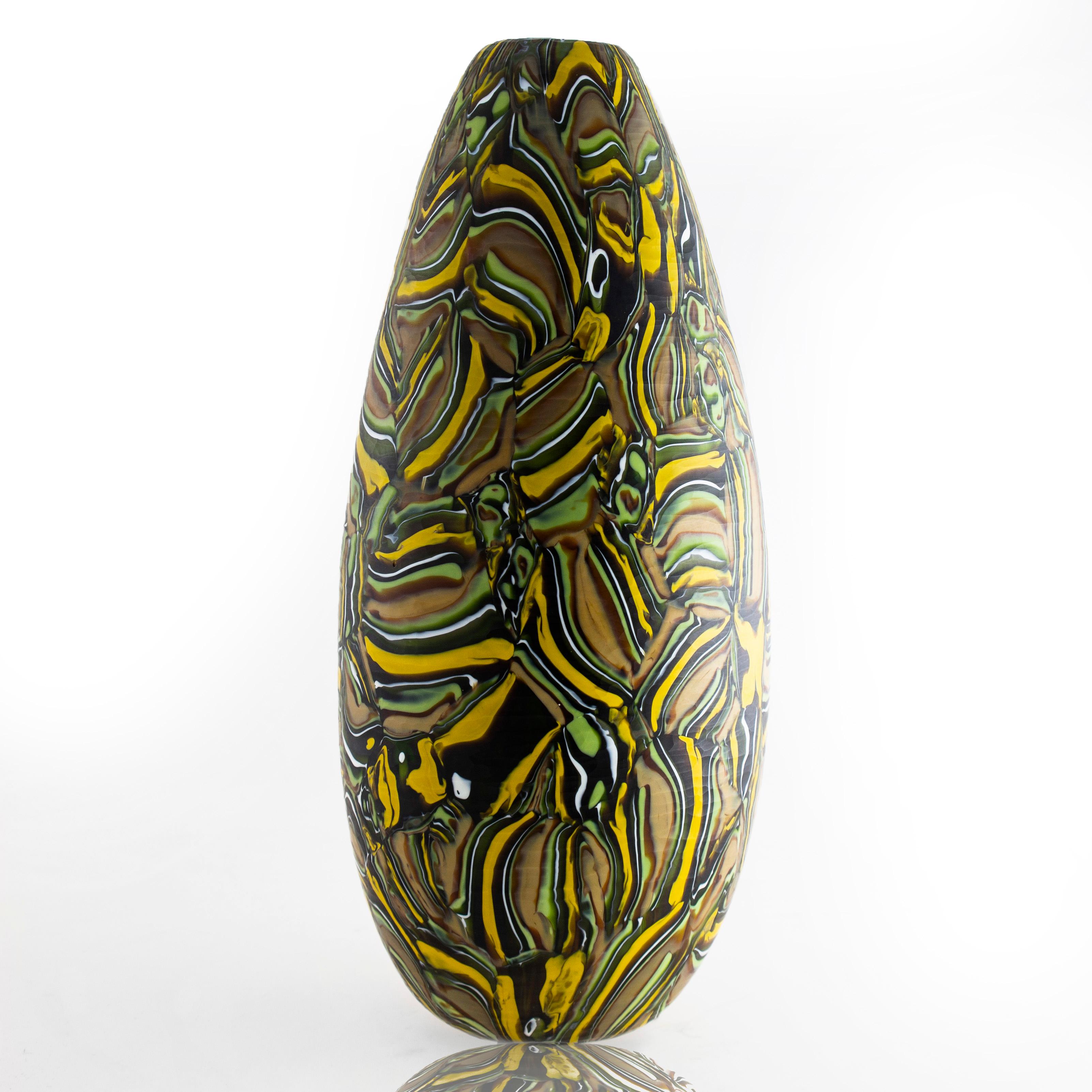 Art glass vase • Handblown by Siemon & Salazar

Velato Strata Murrine mustard/olive tall egg vase
These intensely patterned pieces of art are collections of folded strata murrine that are fused together to create a larger whole. Configurations of