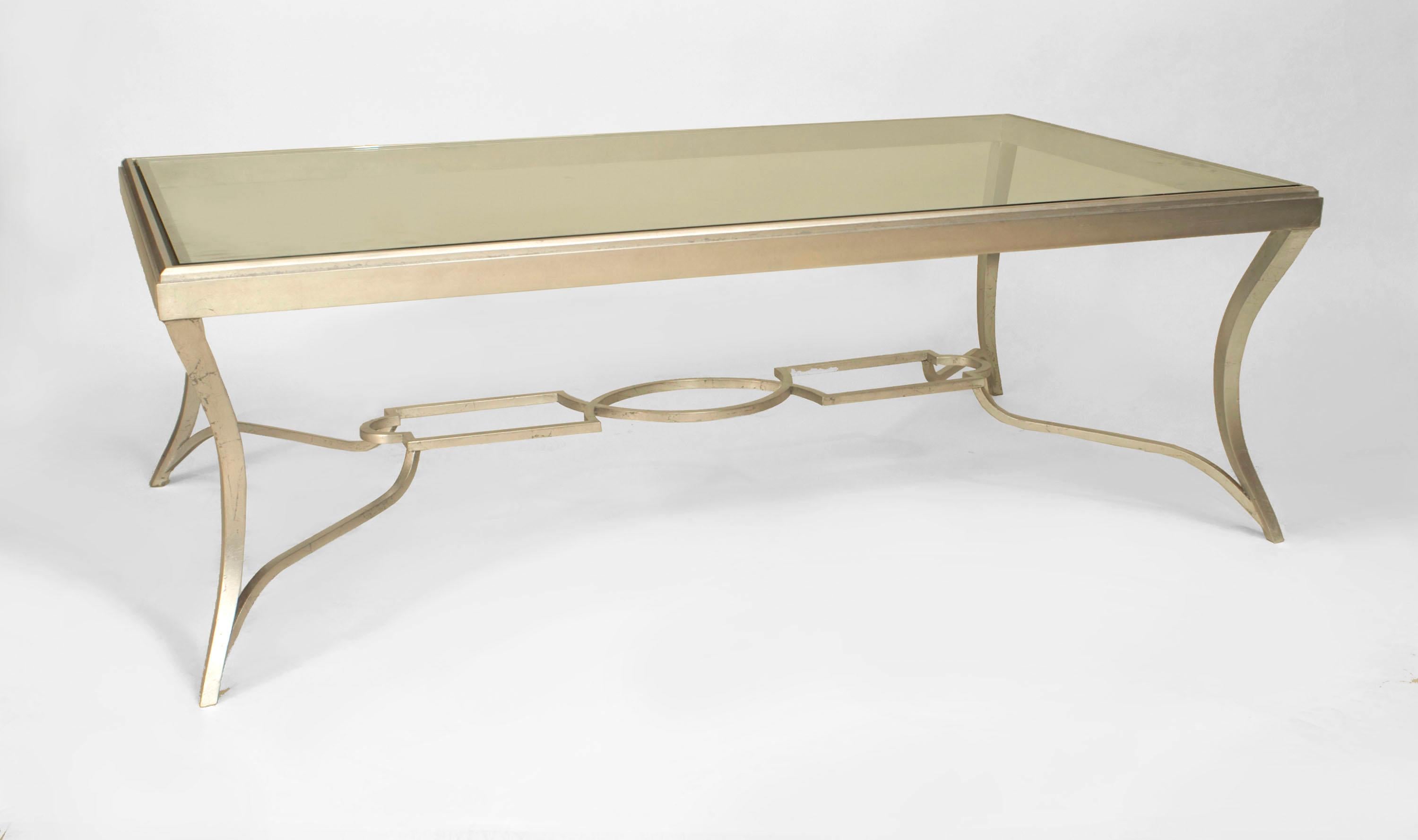 Art Moderne-style rectangular coffee table with silver patinated bronze base, four cabriole legs, and an openwork stretcher with an inset glass top.
