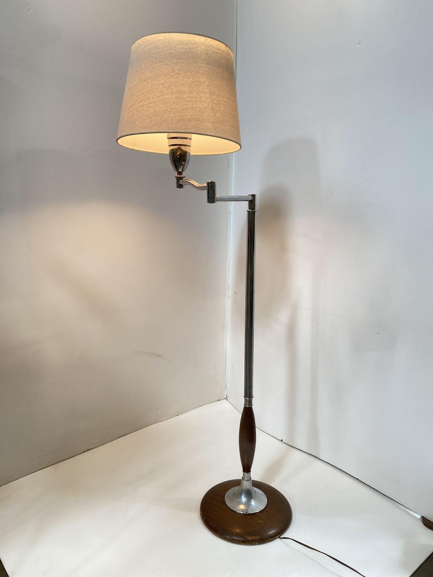 A combination of walnut and chrome design base floor lamp with swing arm made in United States in the 1950's.
