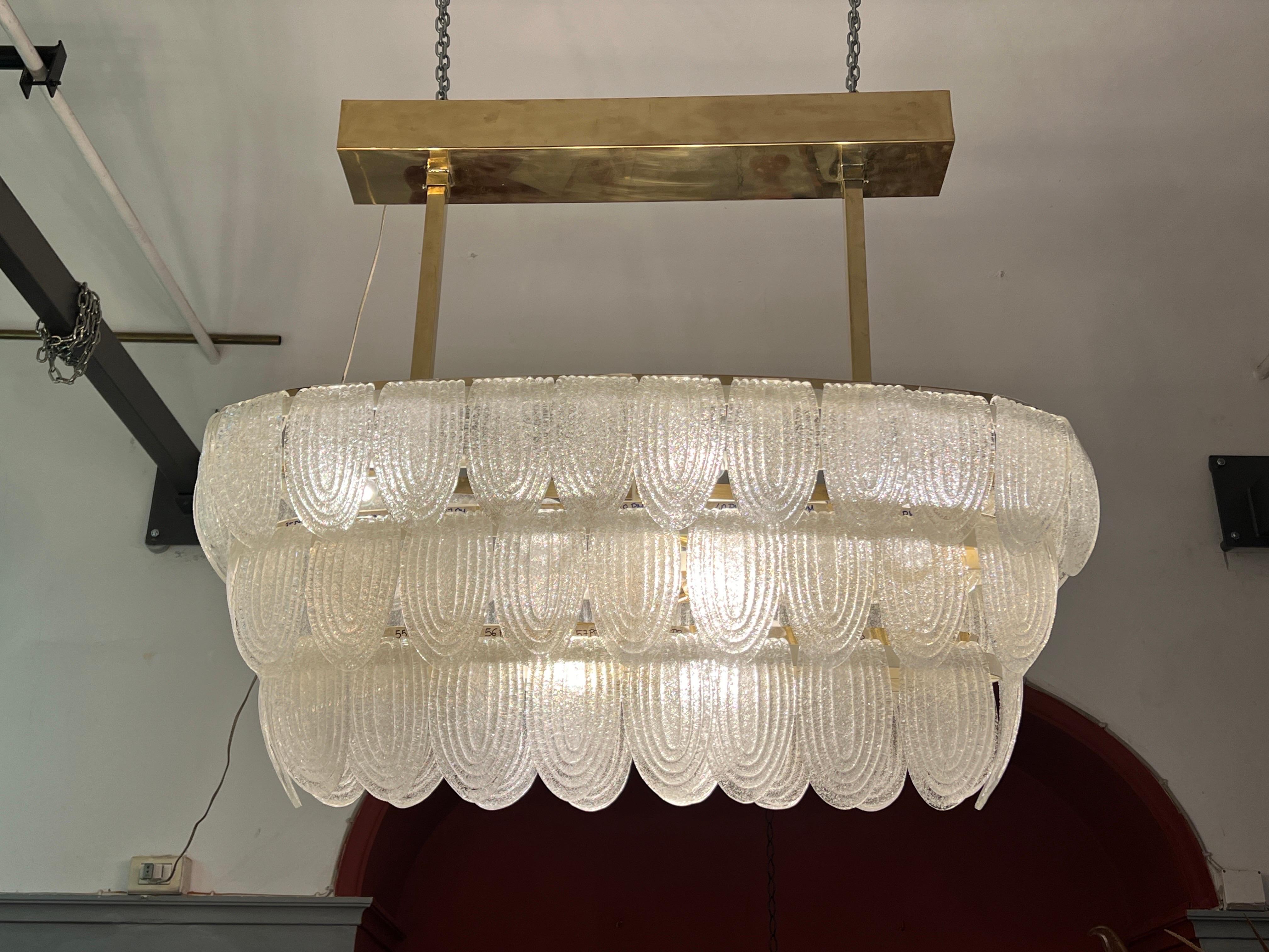 Art Deco Murano Pulegoso Clear Glass Oval Chandelier with brass fittings.
The Pulegoso glass appears full of bubbles, it is rough and pitted on the surface.
The chandelier has 9 light bulbs.