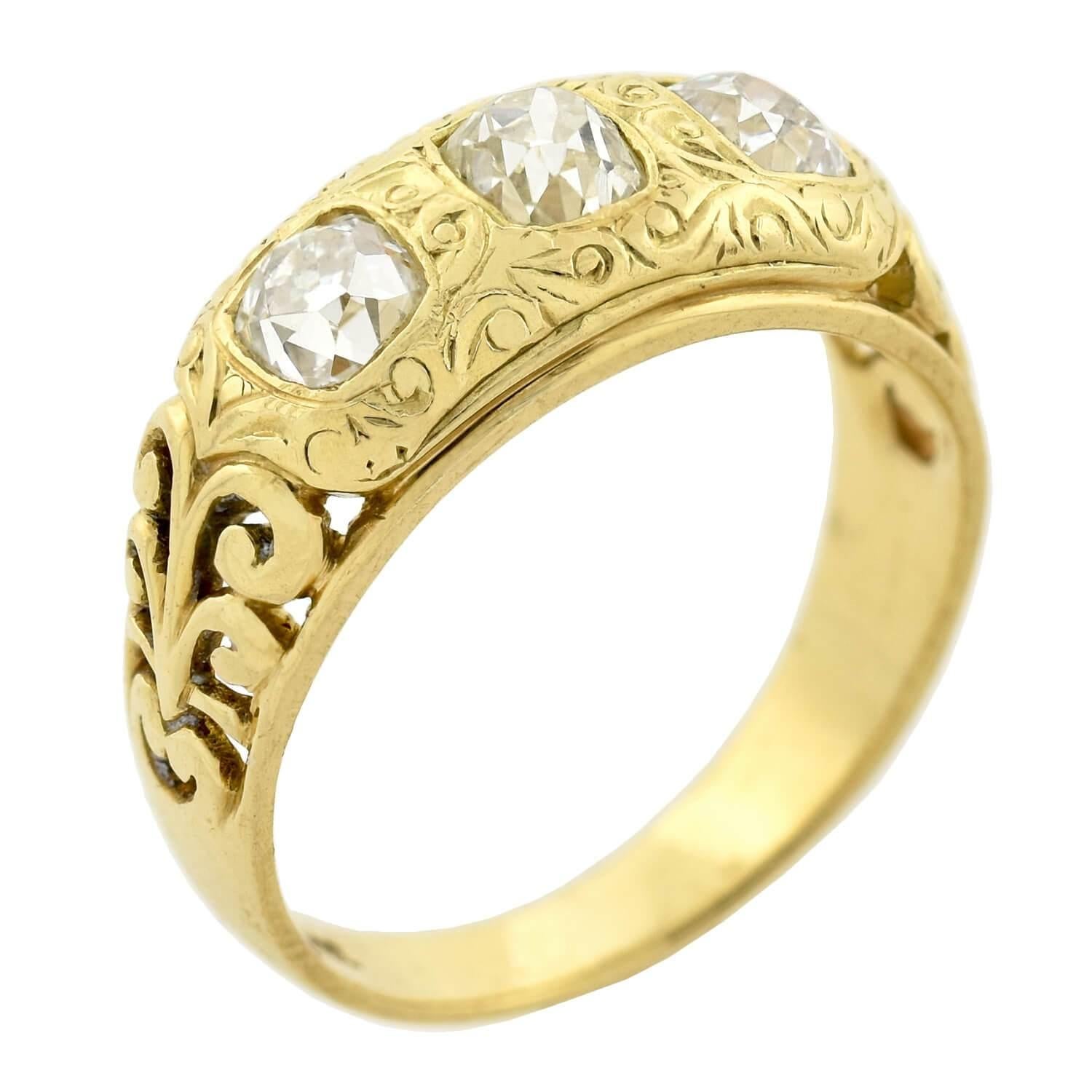 An absolutely gorgeous 3-stone ring from the Art Nouveau (ca1900s) era! This wonderful piece is crafted in bright 18kt yellow gold and features a trio of diamonds bezel set within the face of the ring. The three old Cushion Mine Cut diamonds have a