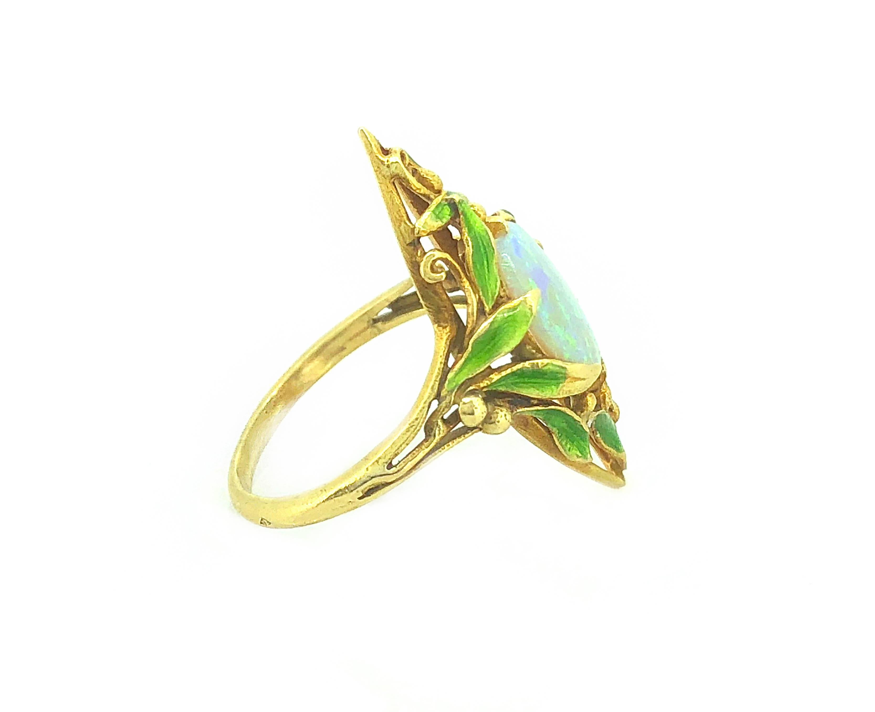 A very rare Art Nouveau opal and enamel Antique fashion ring featuring a 1.33ct. apx. opal that has a white base with lively blue and green color with some orange and purple. It is meticulously filigreed and possesses beautiful green enameling