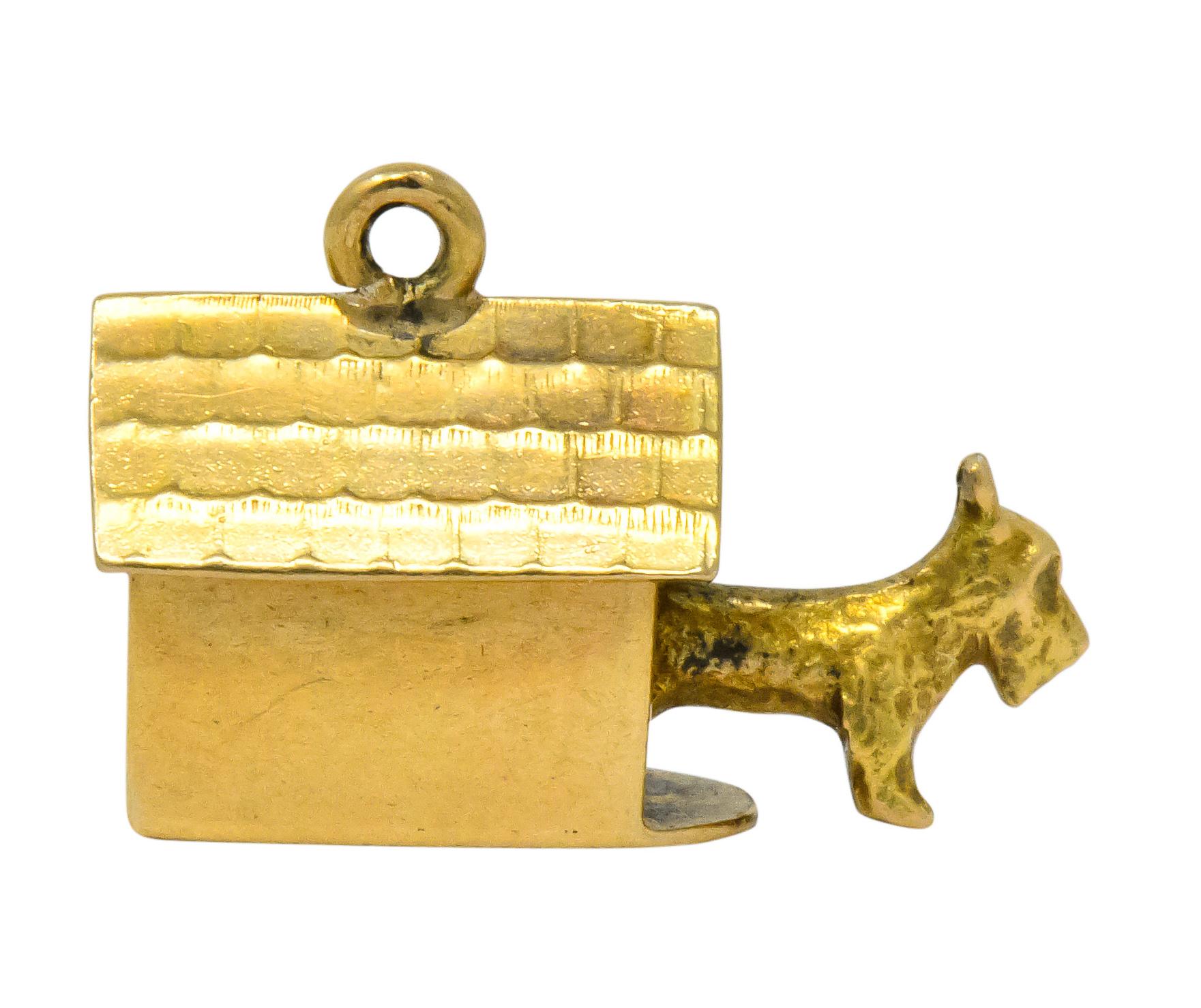 Charm designed as a doghouse with engraved shingles and an articulated Scottish Terrier joyfully peaking out

Completed by jump ring atop pitched roof

Stamped 14k for 14 karat gold

Circa 1910

Measures: approx. 1/4 x 5/8 (with dog fully extended)