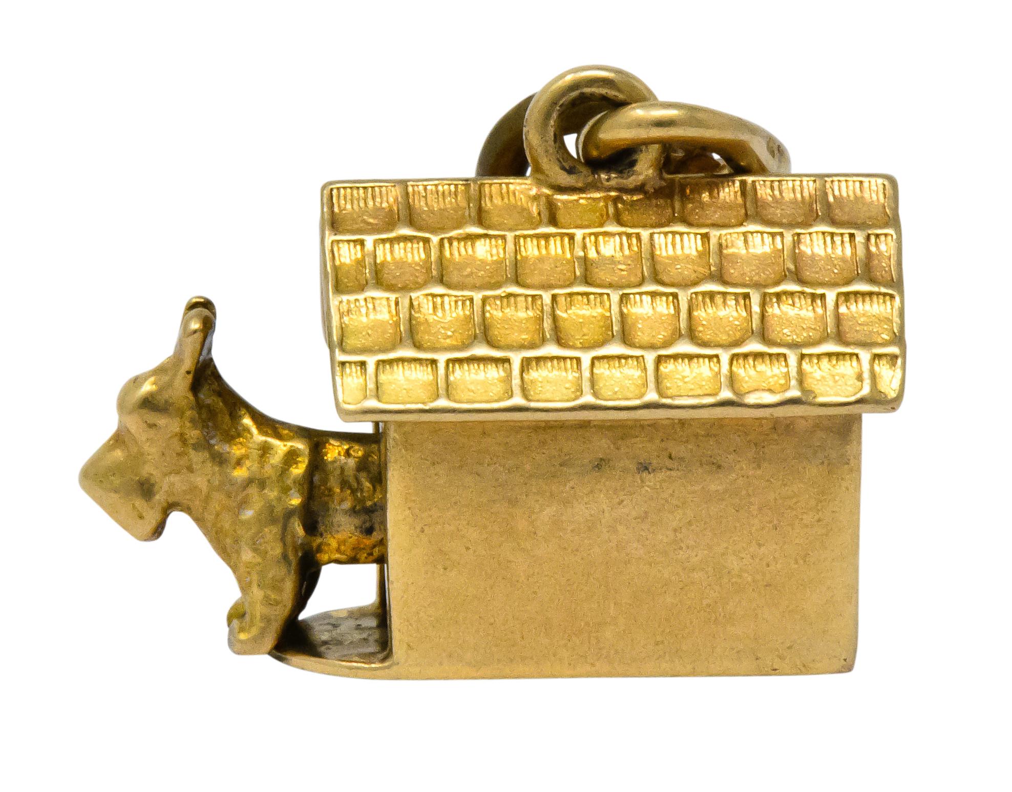 Charm designed as a doghouse with engraved shingles and an articulated Scottish Terrier joyfully peaking out

Completed by jump ring atop pitched roof

Stamped 14k for 14 karat gold

Circa 1910

Measures: approx. 1/4 x 9/8 (with dog fully extended)