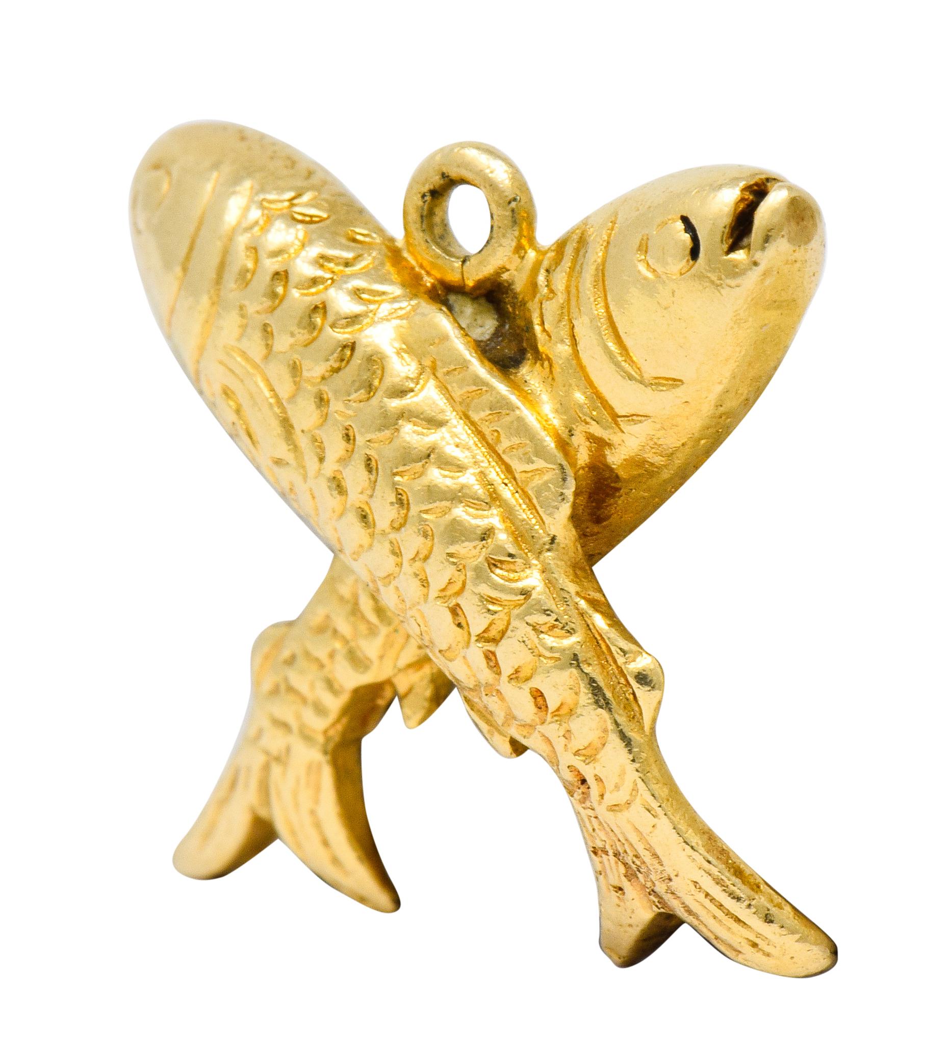 Charm designed as two fish crossed

Each with stylized faces and deeply engraved scalloped scales

Completed by jump ring bale

Tested as 14 karat gold

Circa: 1910

Measures: 1/2 x 5/8 inch

Total weight: 4.3 grams

Leaping. Double-Trouble.
