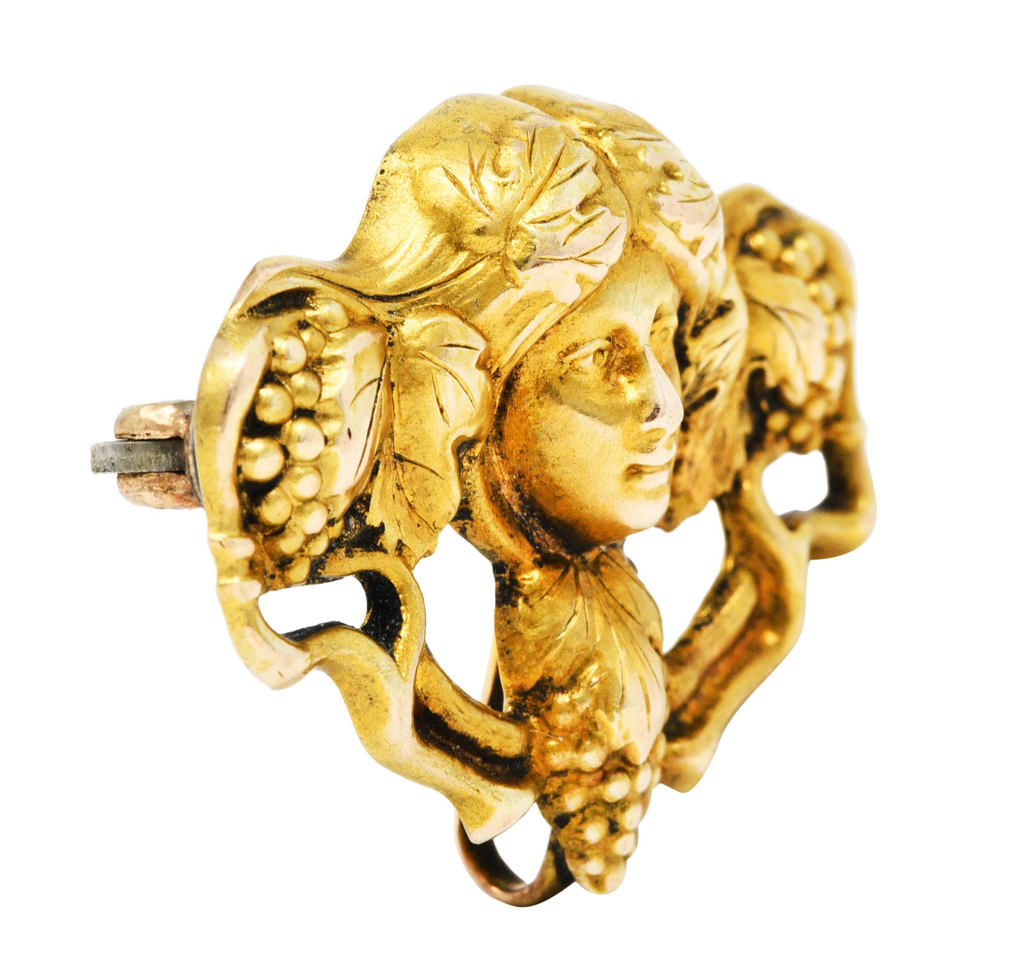 Highly stylized brooch depicts a female maenad - a follower of Dionysus

Hair is entangled with grape leaves and whiplashed vines

With three bunches of grapes - an icon of Dionysus and symbolic of plentifulness

Completed as a pin stem with